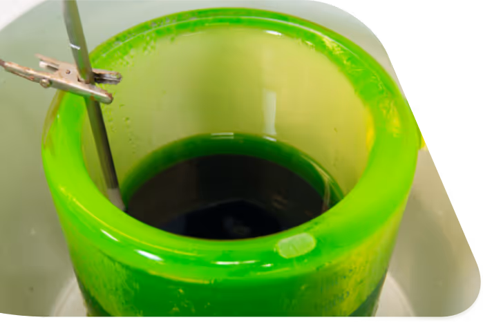 A close up of a green cup with a toothbrush in it.