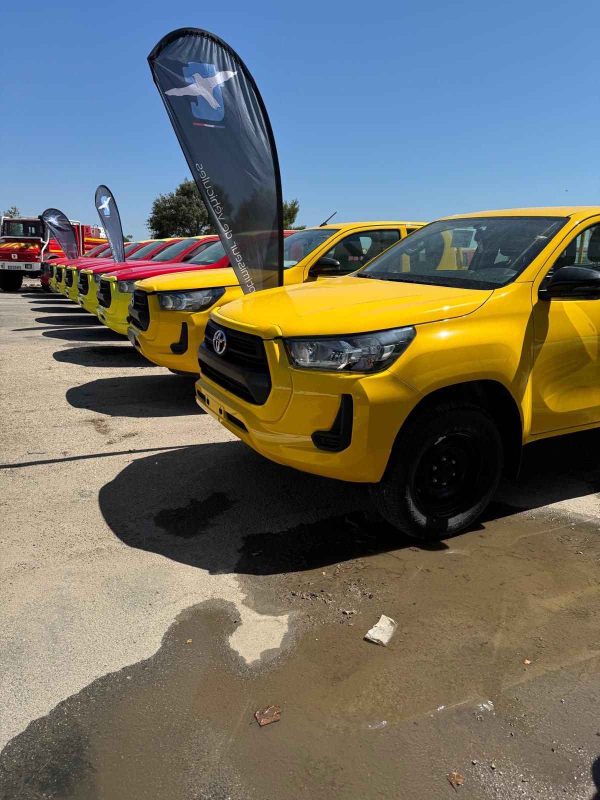 Technamm yellow civilian vehicles lined up outside.