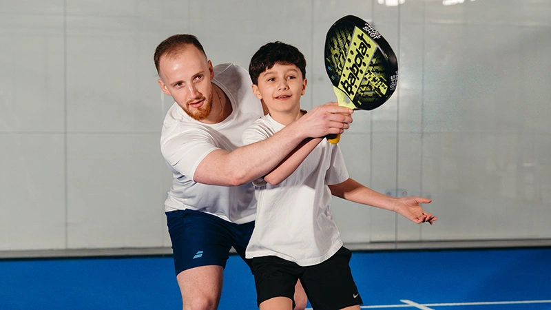 Professeur de padel avec son jeune élève