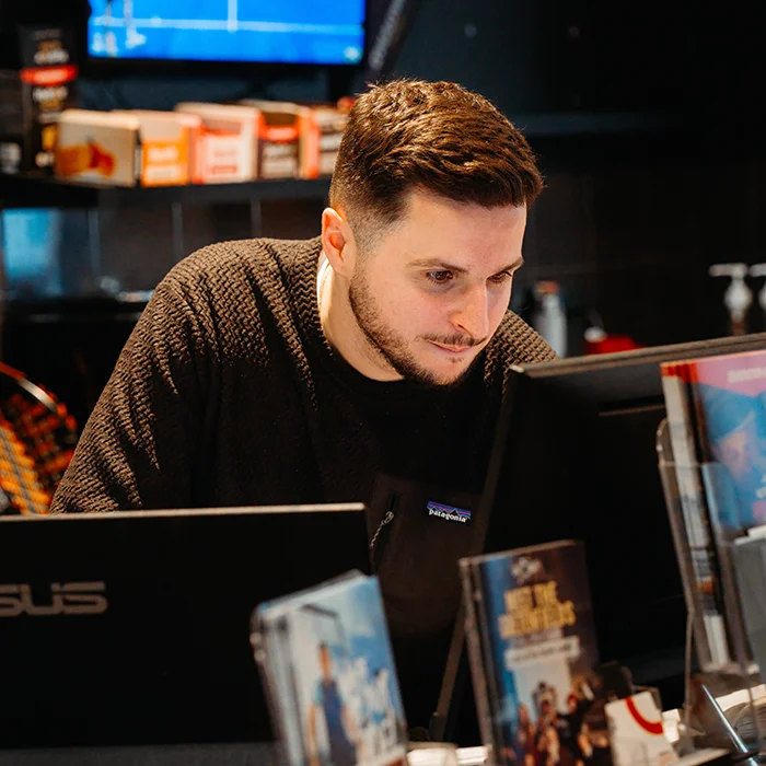 Salarié PadelShot derrière comptoir accueil