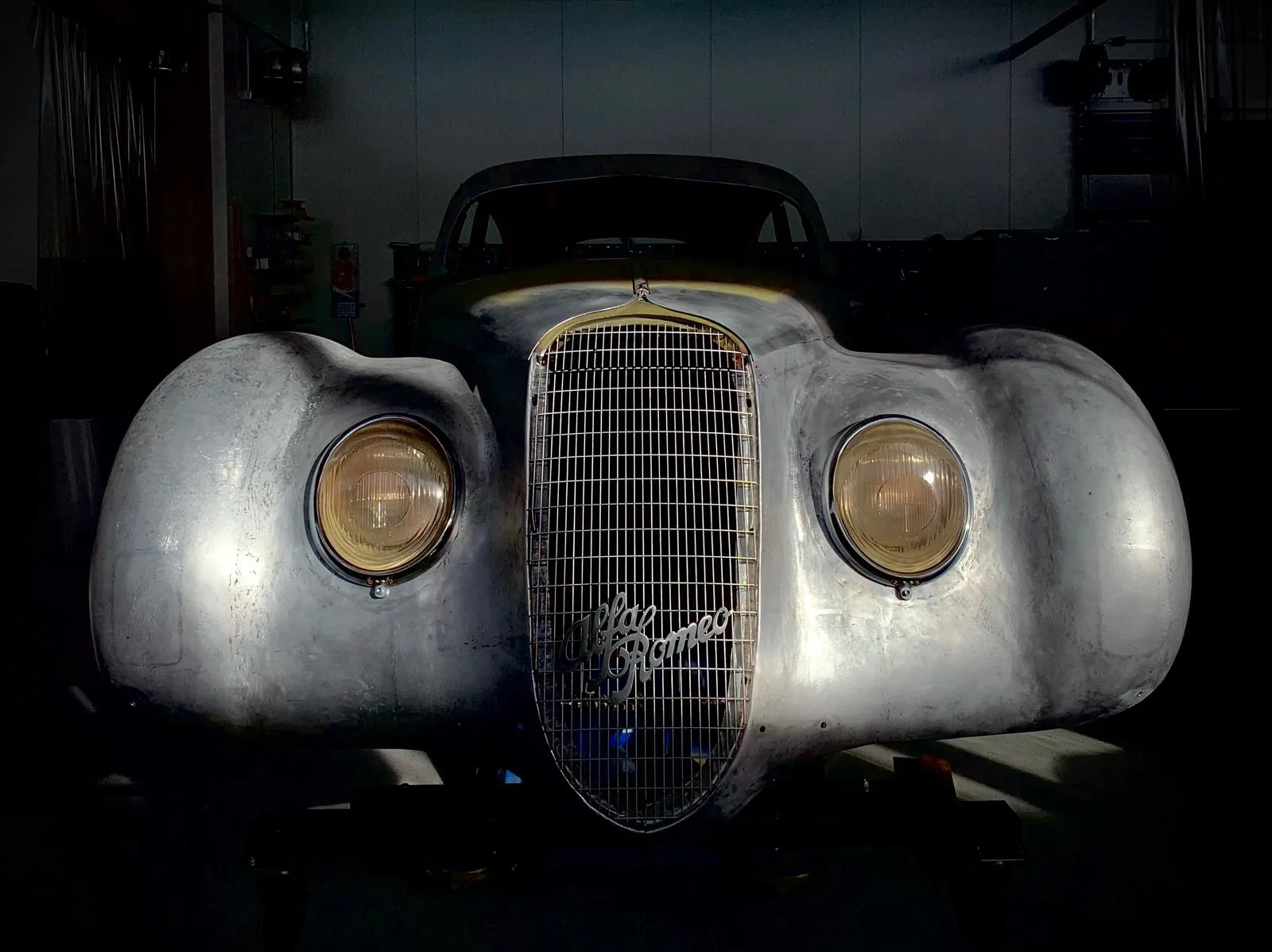 A picture of a front of an old Alfa-Romeo with yellow headlights