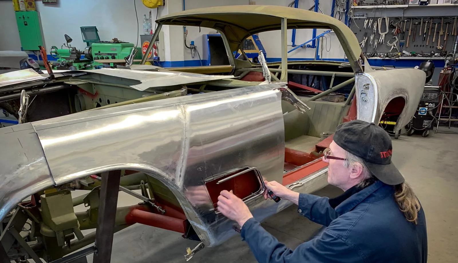 A worker of Benefit Auto Klassika working on an old Maserati
