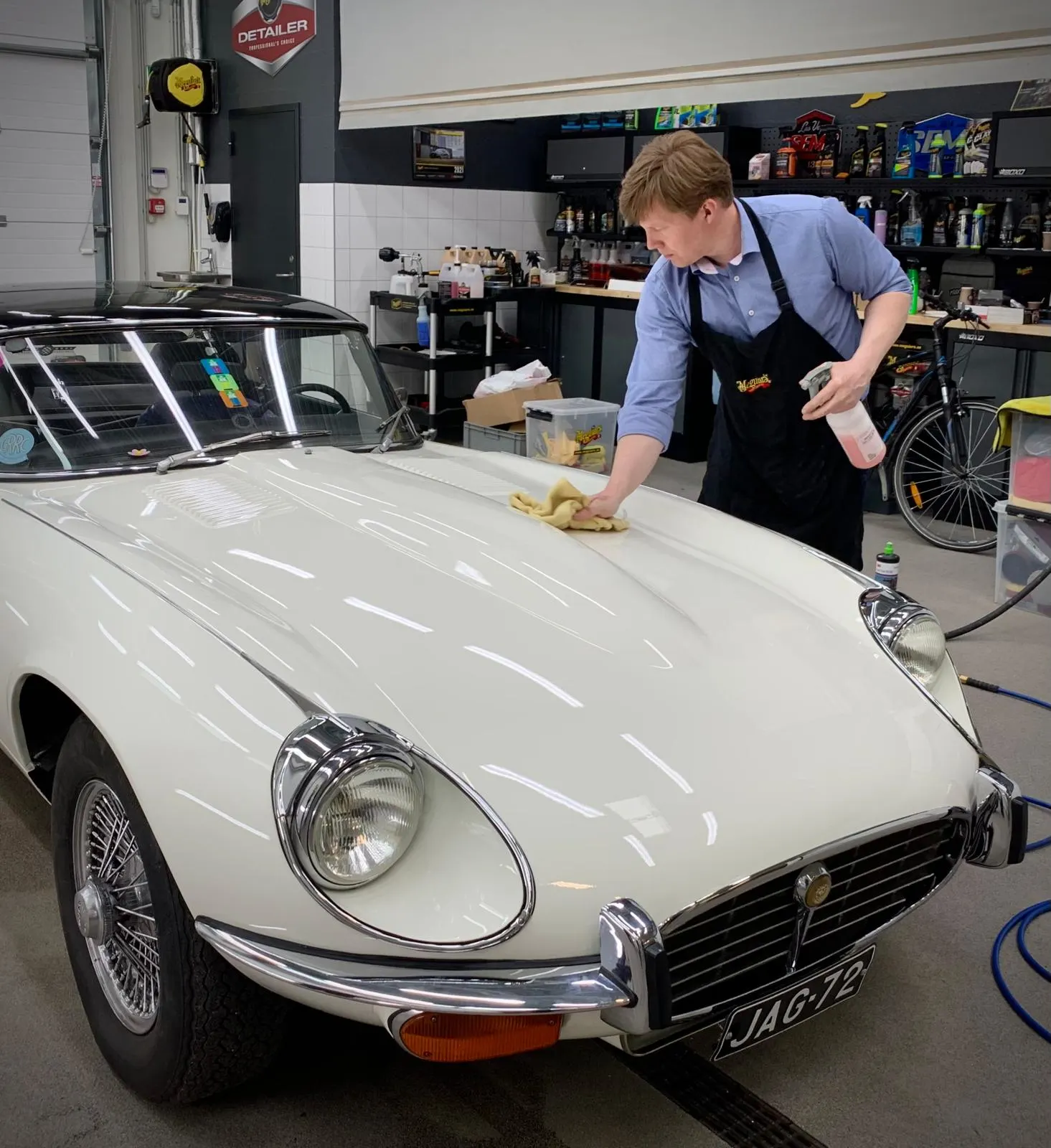 Raul vello of Benefit cleaning and polishing an old Jaguar E-Type with Meguiar's products