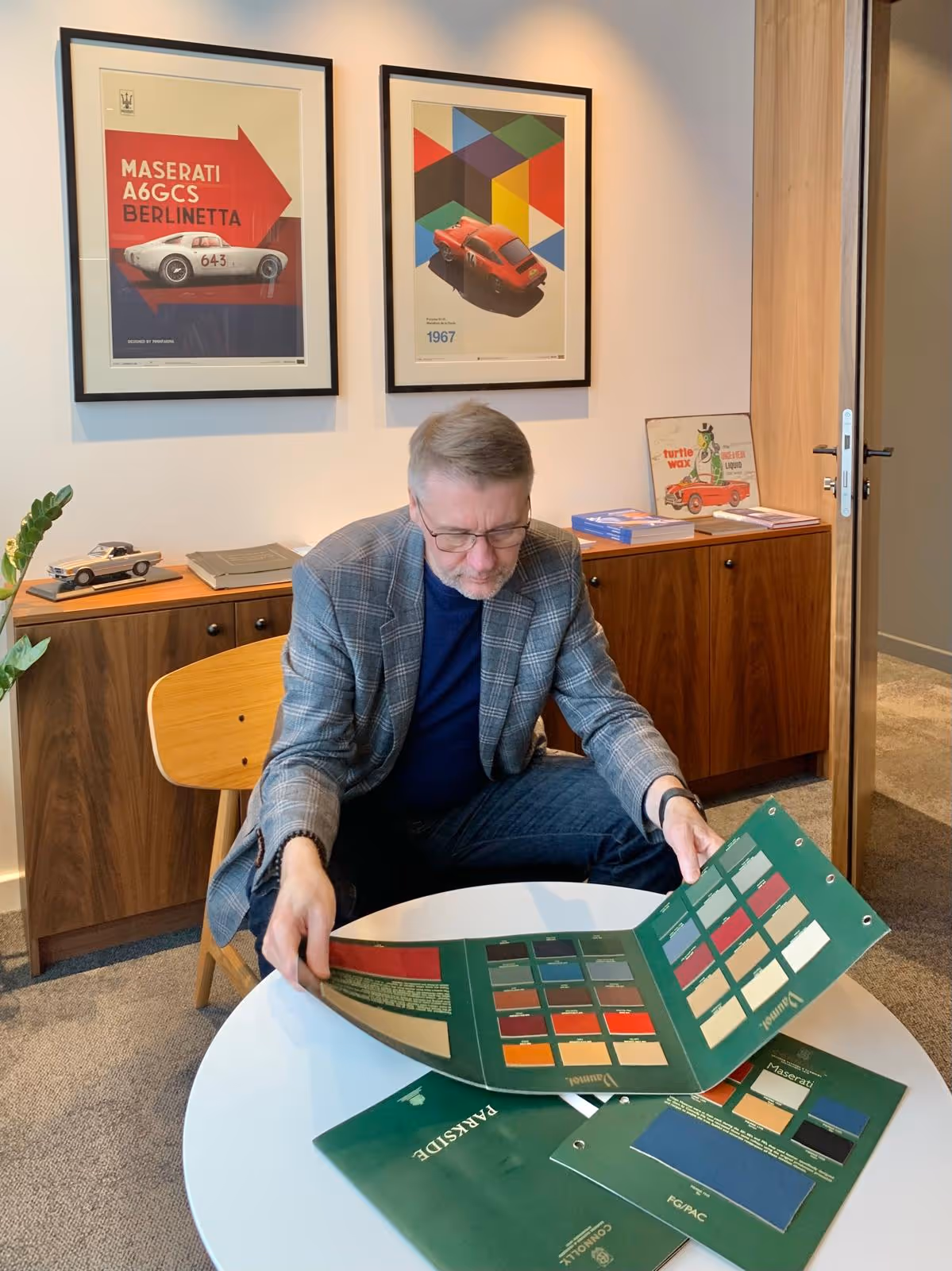 Sulev Narusk sitting in an office choosing materials for car interior upholstry