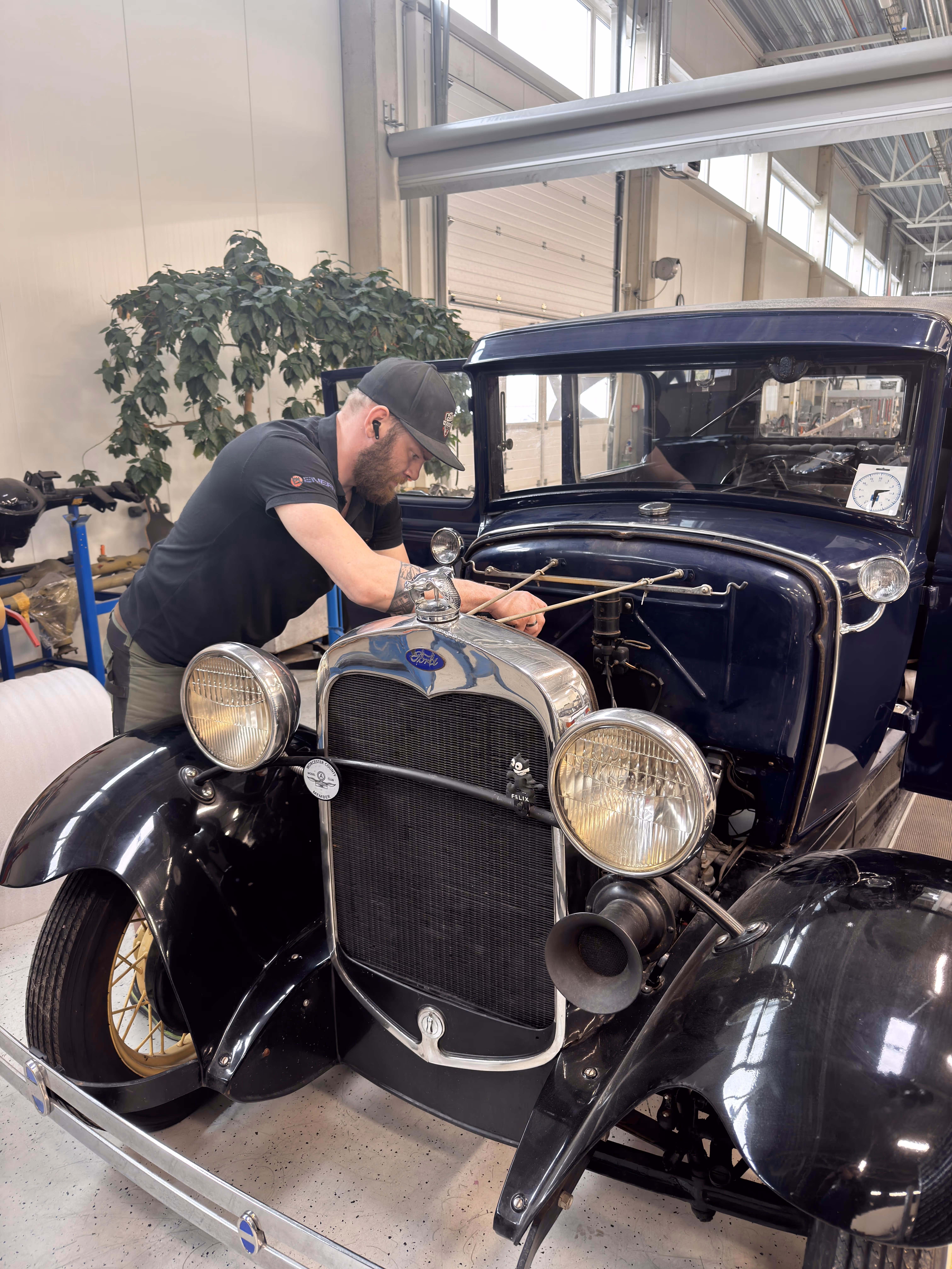 A mechanic servicing a Ford Model T
