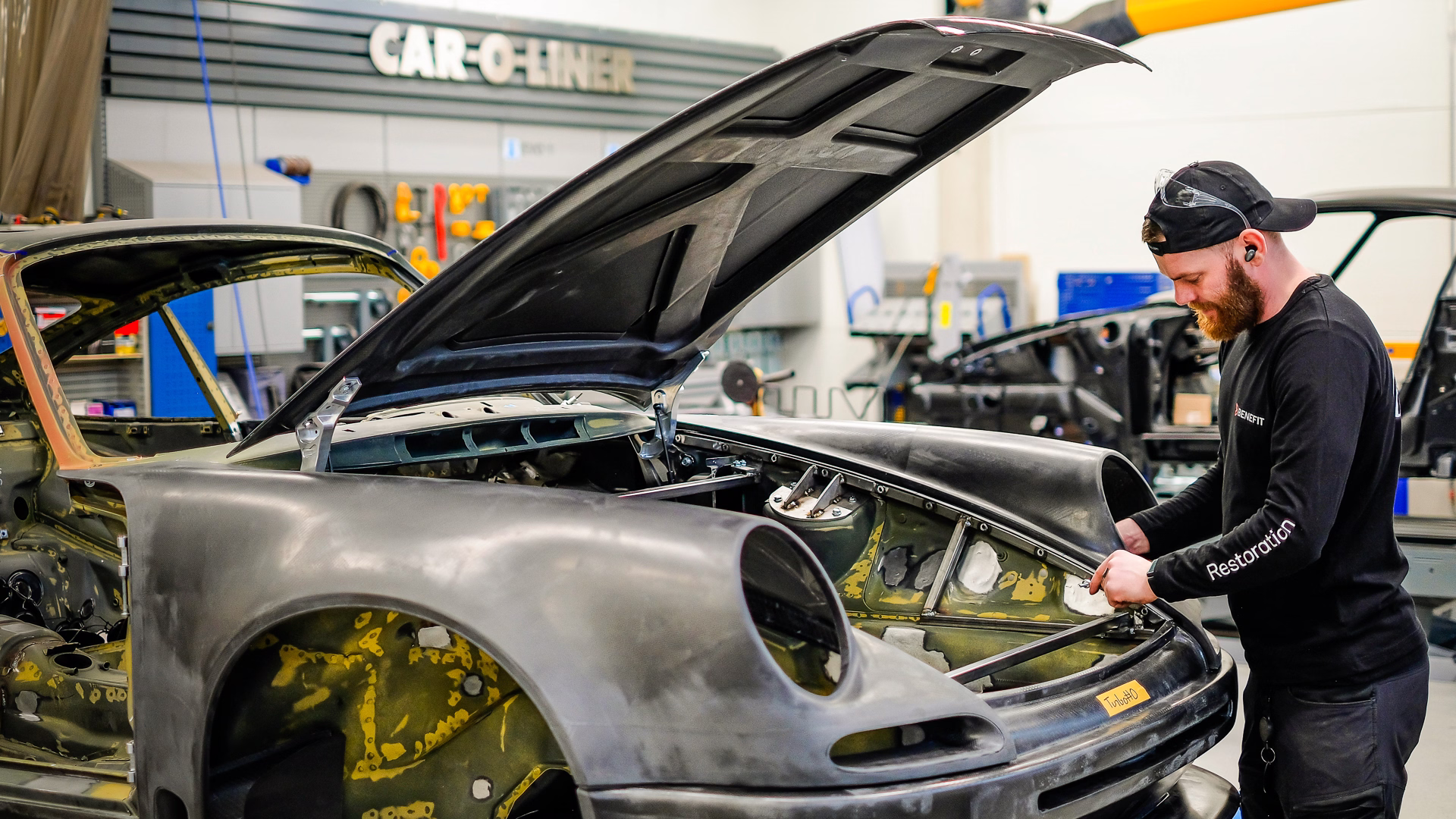 Hendrik Tasa doing chassis work on a Porsche 911 with carbon bodywork