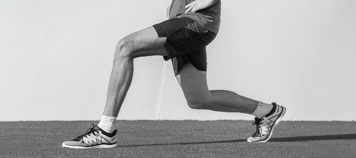 Close-up of a person’s legs performing a forward lunge.