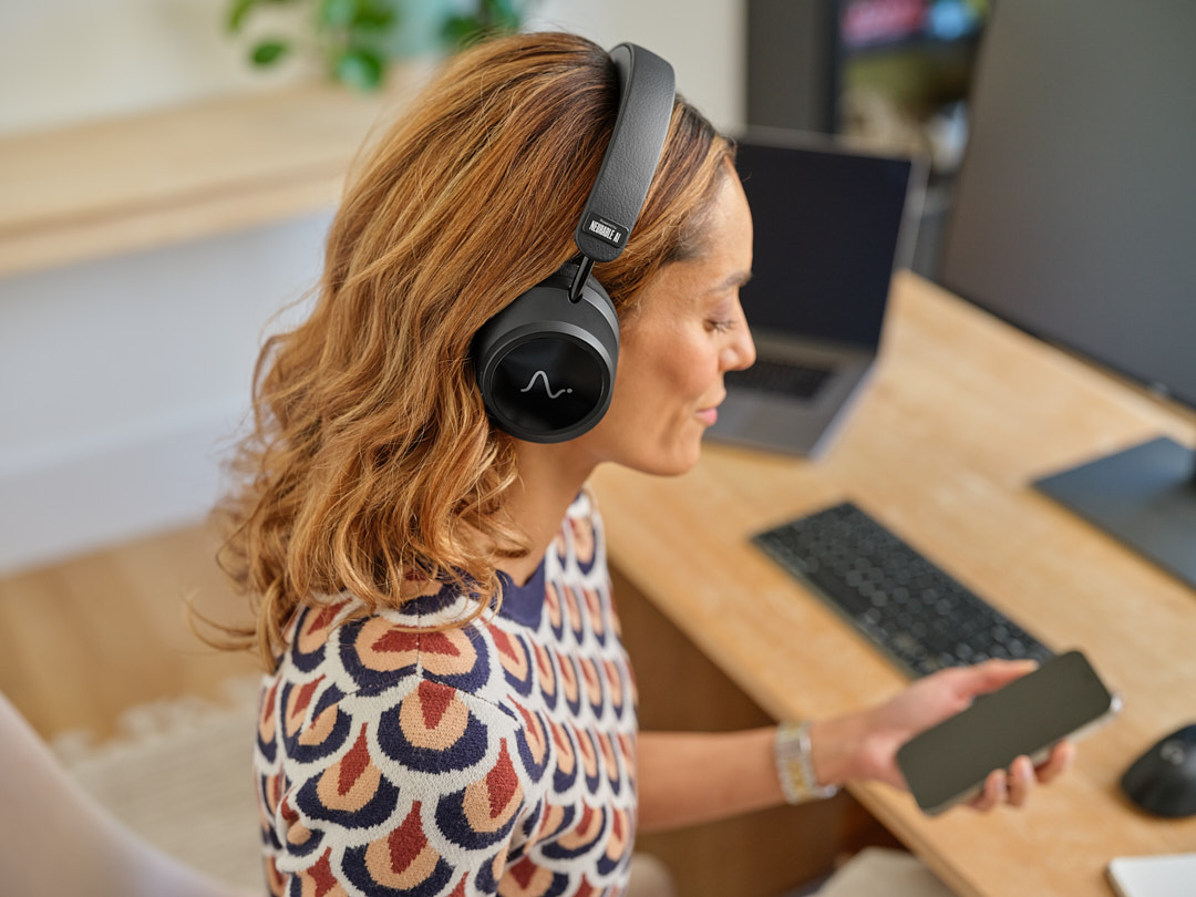 Woman at a desk wearing Neurable One headphones