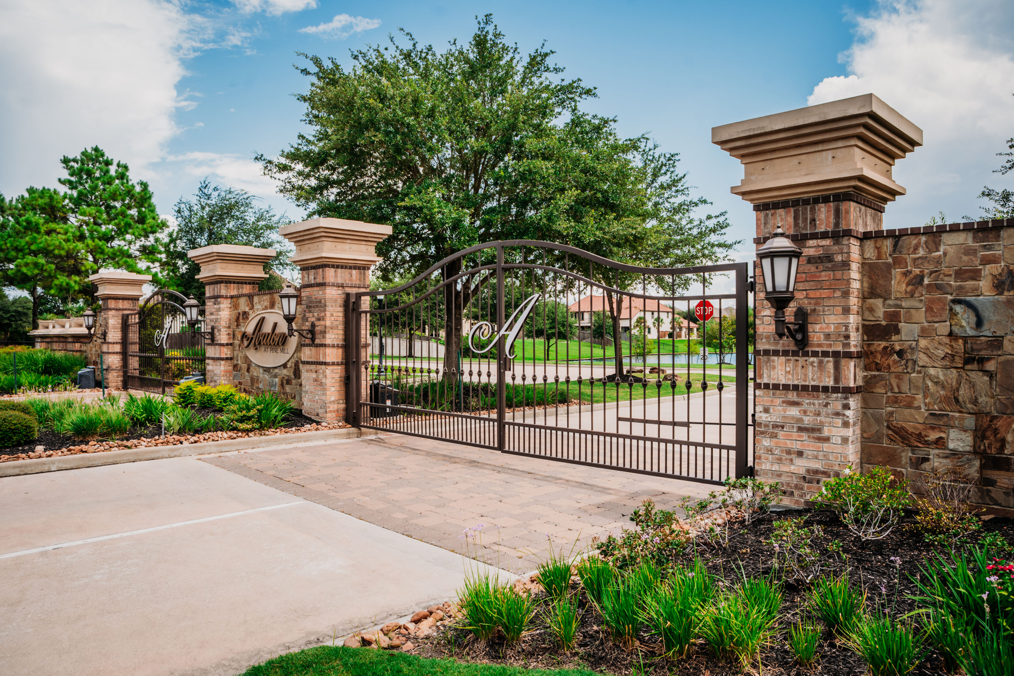 Ornamental Iron Vehicular Entry Gate set against Decorative wall and columns.