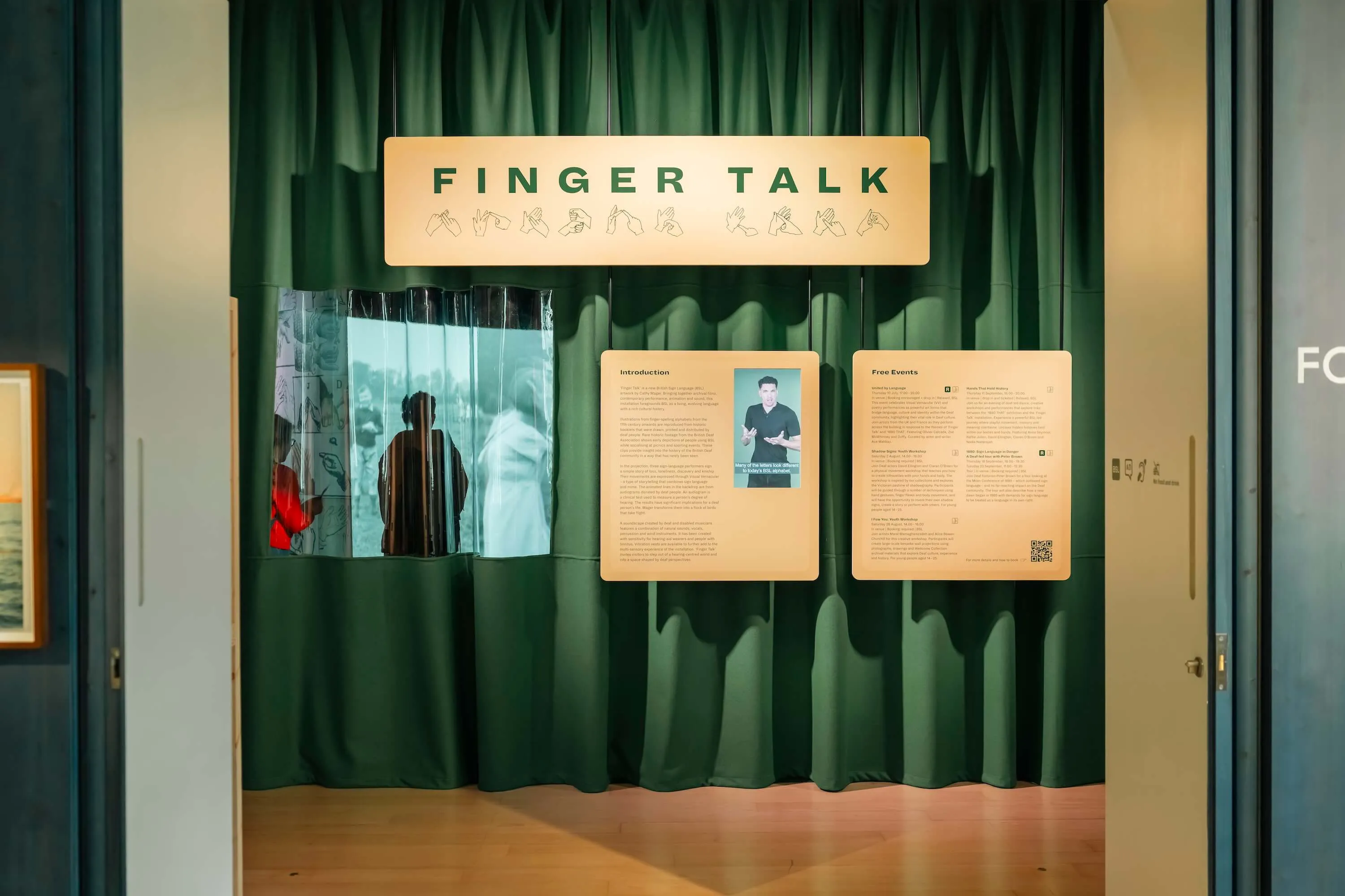 Photo of the entrance to an exhibition titled 'Finger Talk', consulted by Deaf Architecture Front.