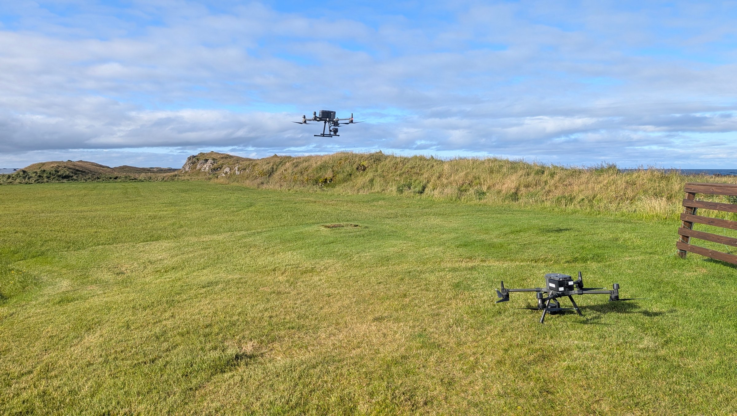 Two Svarmi survey drones on a coastal field in Iceland, one hovering and one on the ground | Svarmi