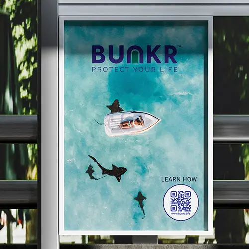 BUNKR bus shelter ad featuring a boat on turquoise water and the line “Protect Your Life.”