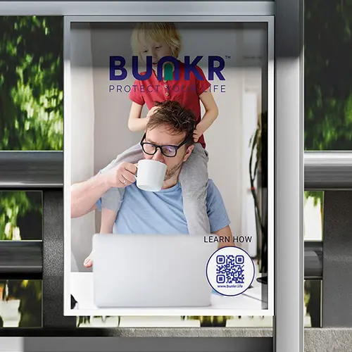 BUNKR bus shelter ad showing a parent at a laptop with a child on his shoulders.