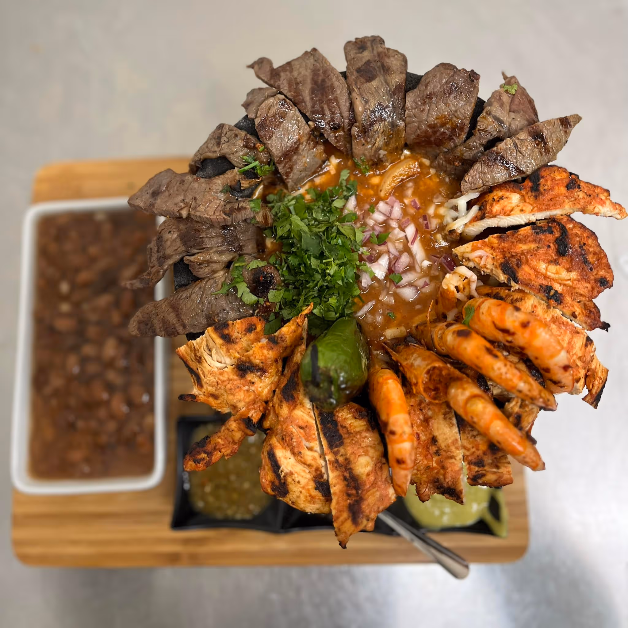 A Cielo Mar y Tierra molcajete with meat, chicken and seafood