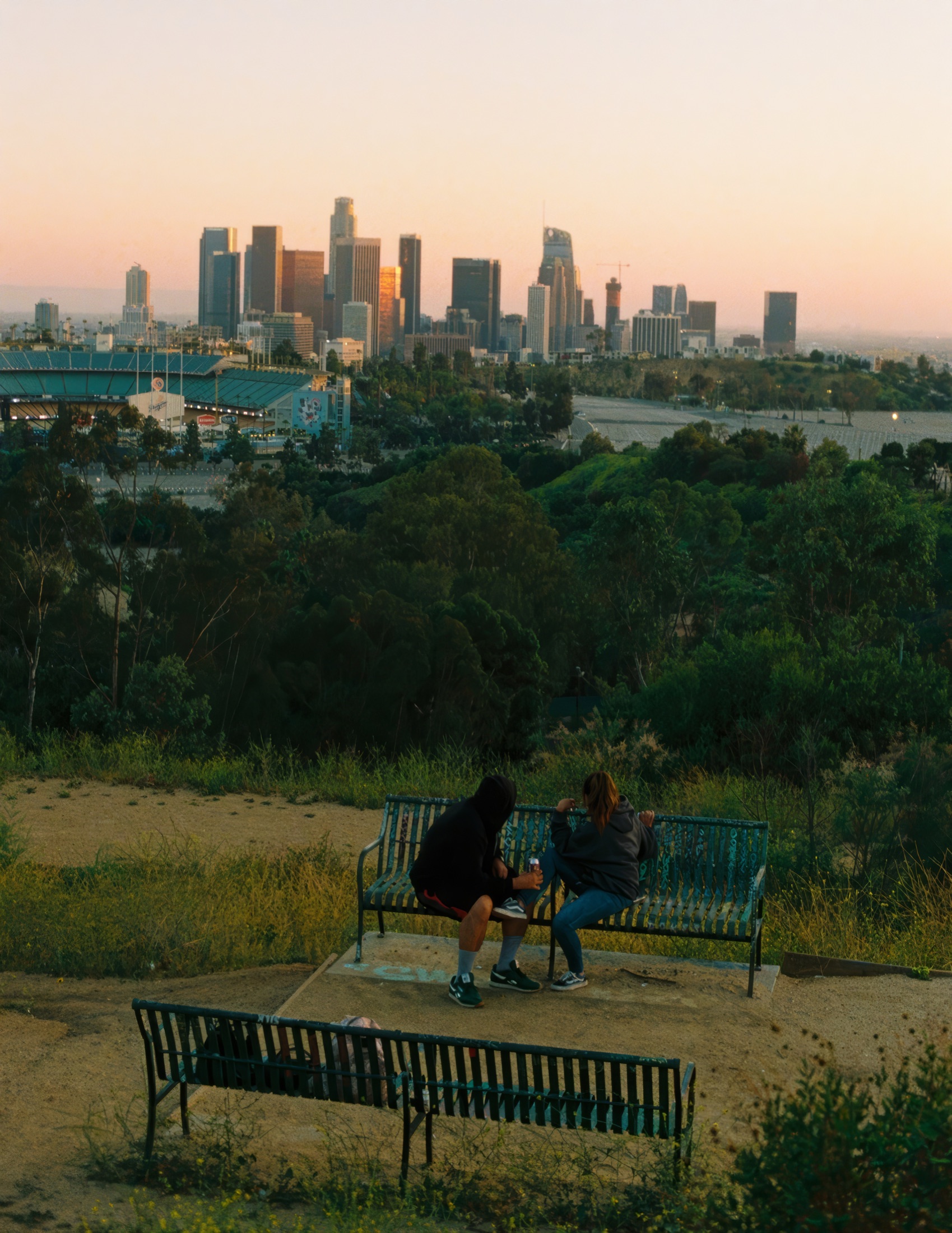 Two people on a bench overlooking a hillside