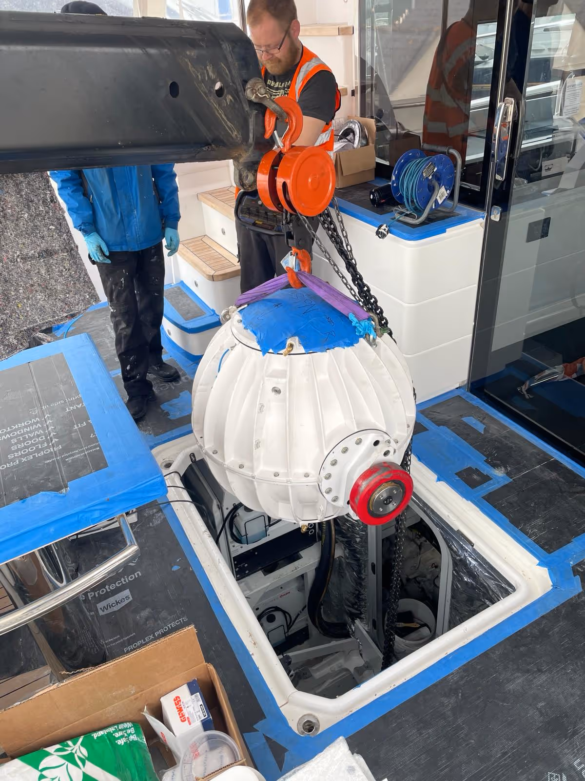 Lowering the new Seakeeper 18 into place with all surfaces carefully protected