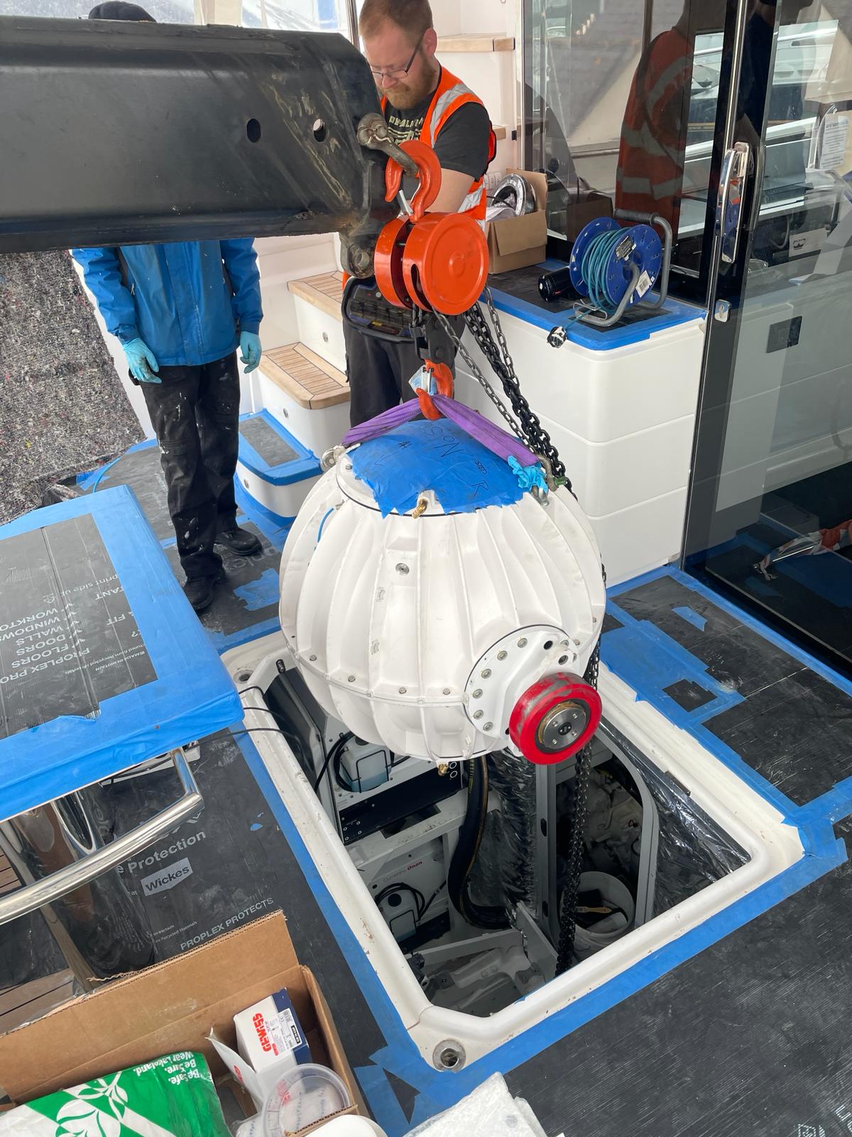 Lowering the new Seakeeper 18 into place with all surfaces carefully protected