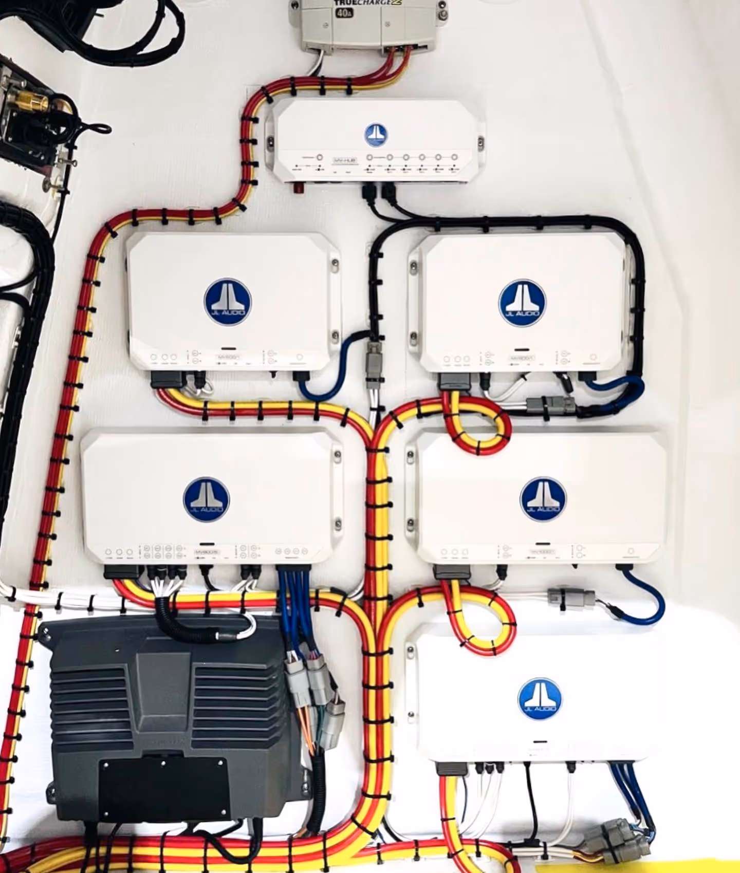 A wiring harness connected to a stereo receiver, with power and ground wires connected to the positive and negative terminals