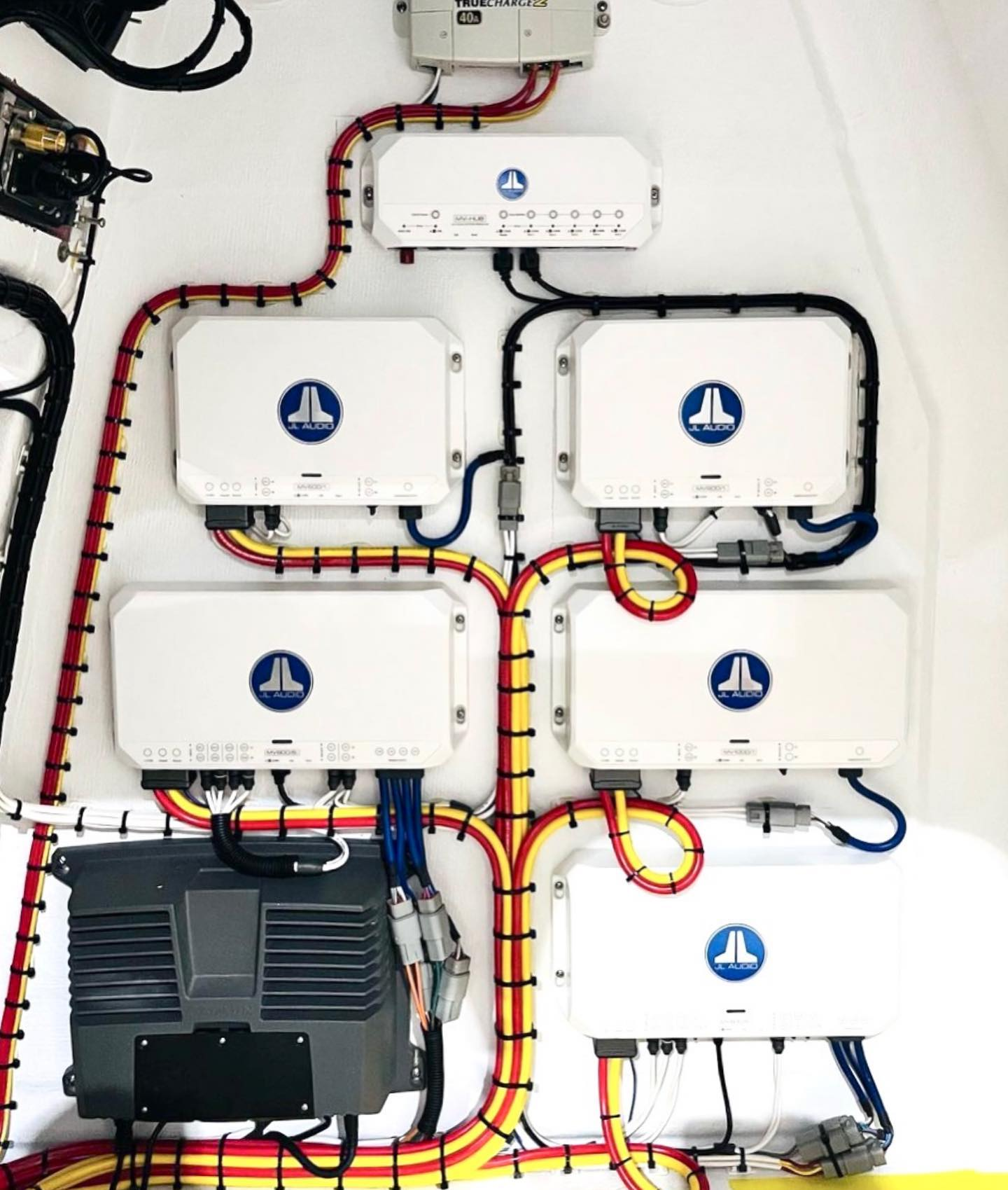 A wiring harness connected to a stereo receiver, with power and ground wires connected to the positive and negative terminals