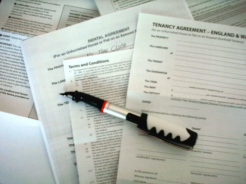 A fountain pen on an open contract showing fine-print clauses.