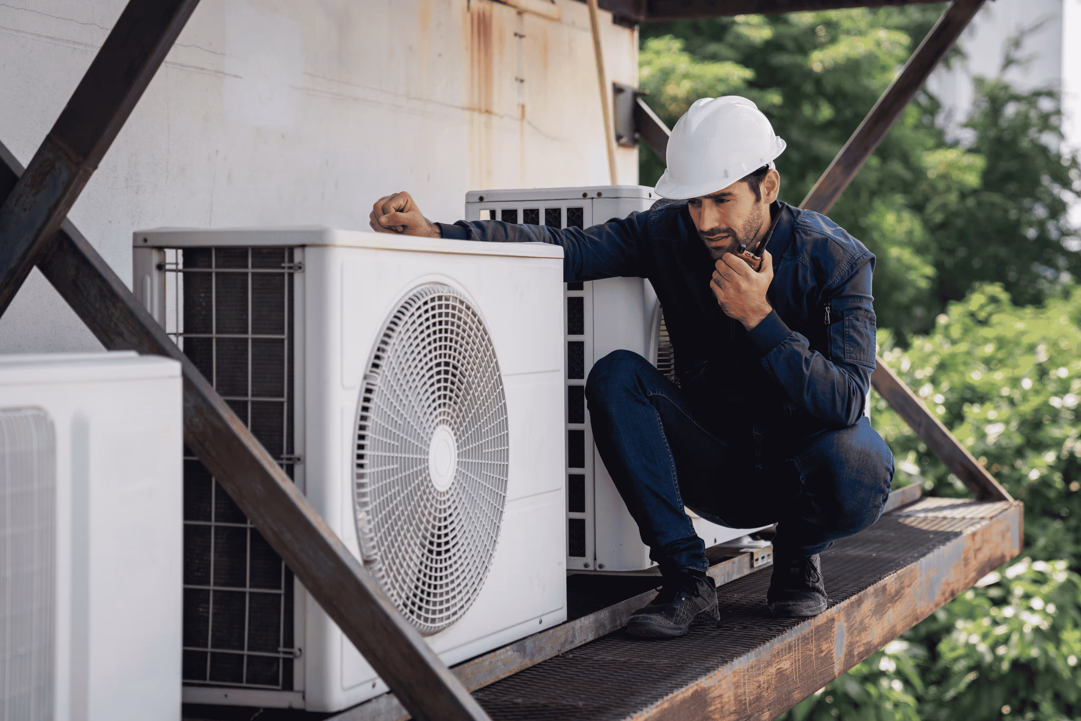 Technician inspecting outdoor AC units