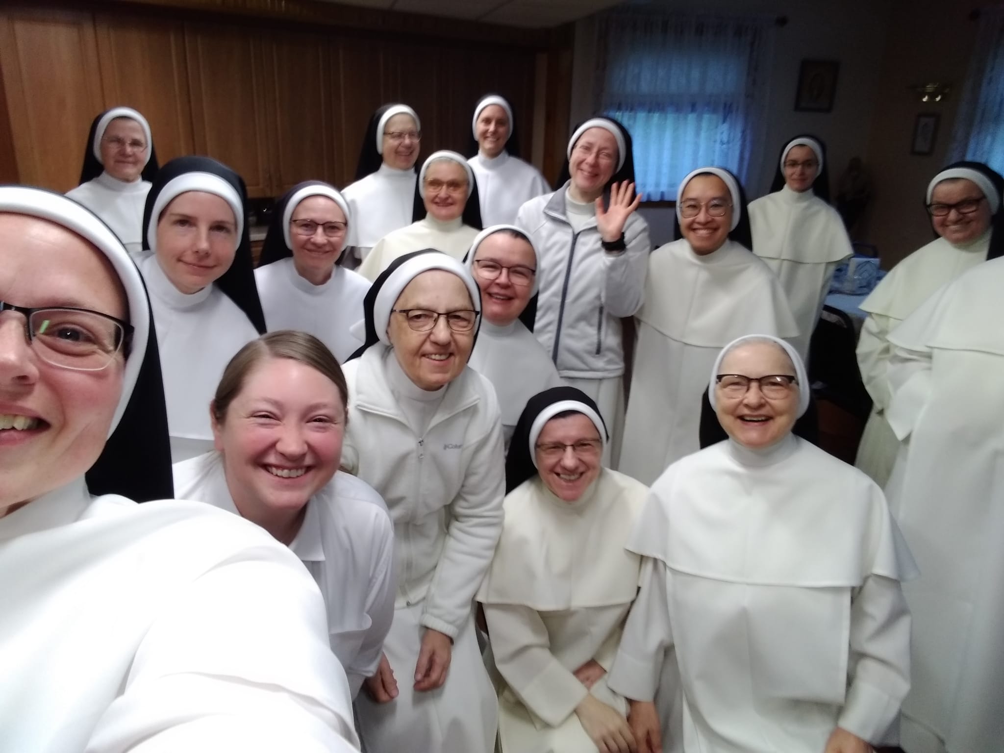 A group of smiling Dominican Sisters waving to the camera.