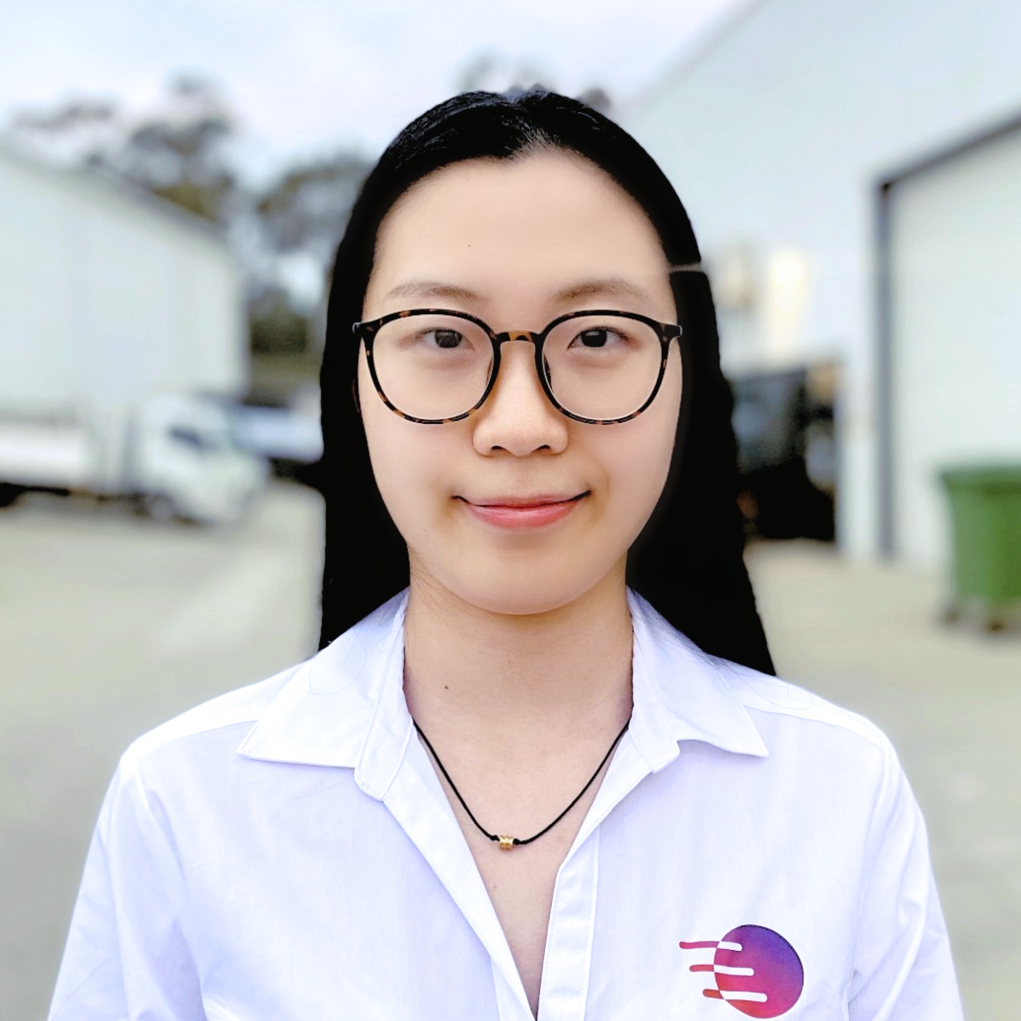 Person with long black hair and glasses wearing a white shirt with a colorful logo on the chest.