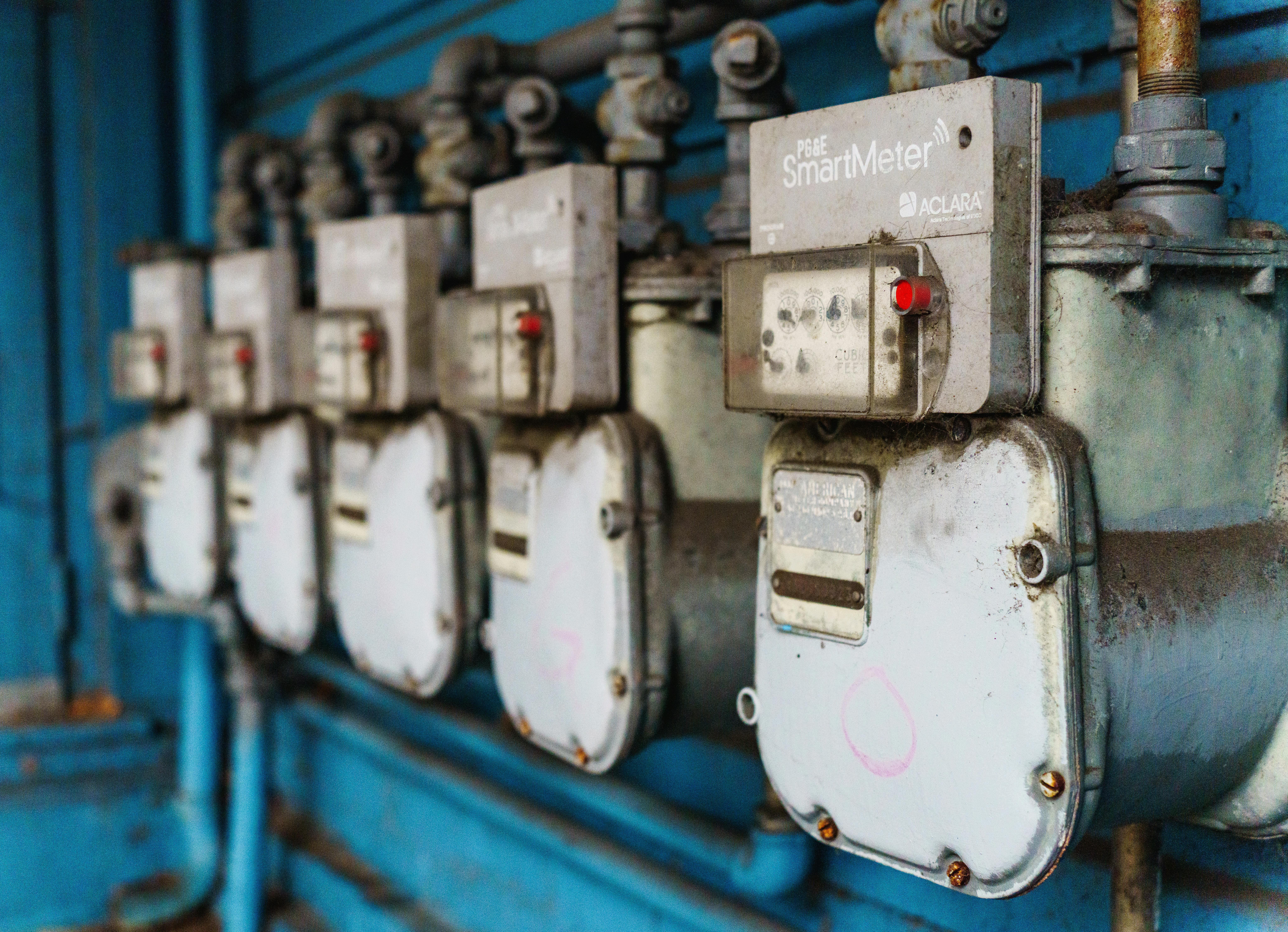 Row of smart utility meters lined up on a wall, representing the metering infrastructure behind time of use tariffs that drive home battery value.