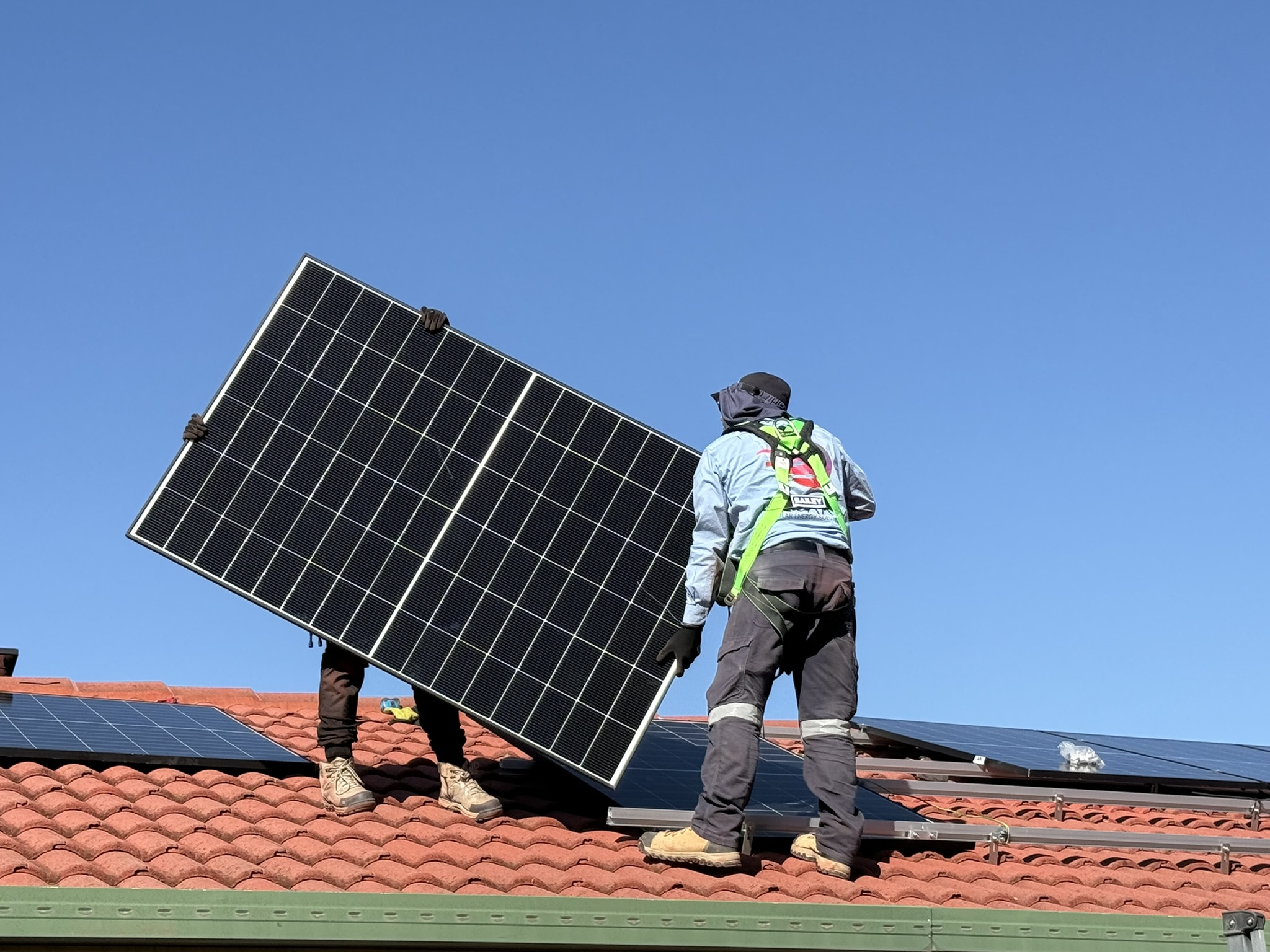 Decarby installers mounting a solar panel on a Canberra residential roof