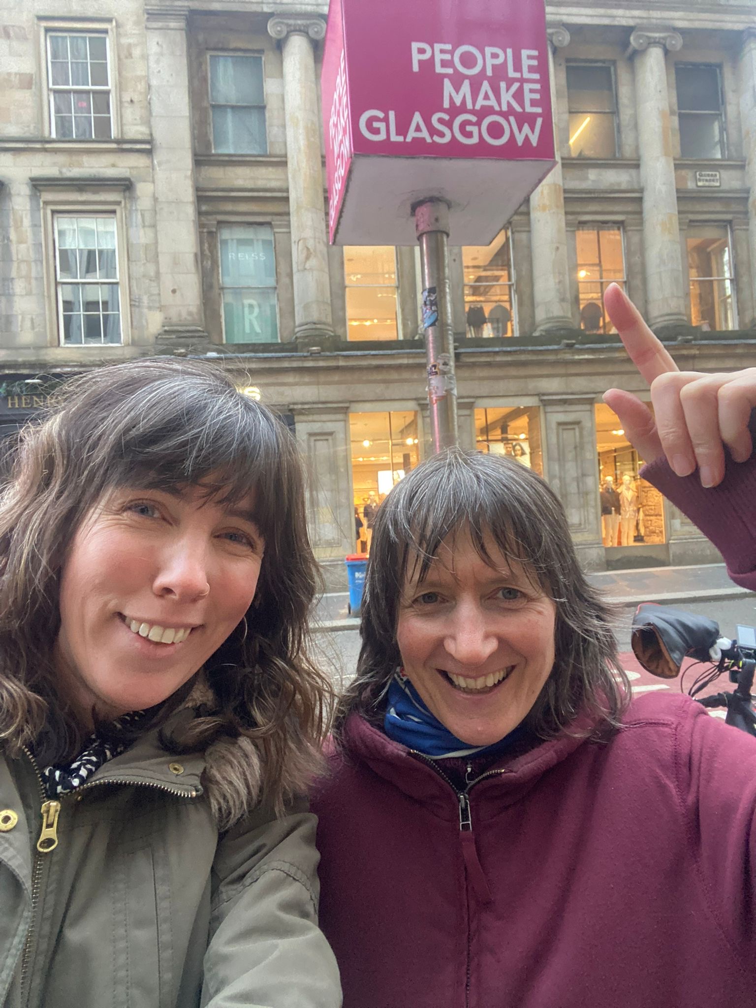 Two members outside Glasgow Central with fire fighters in background