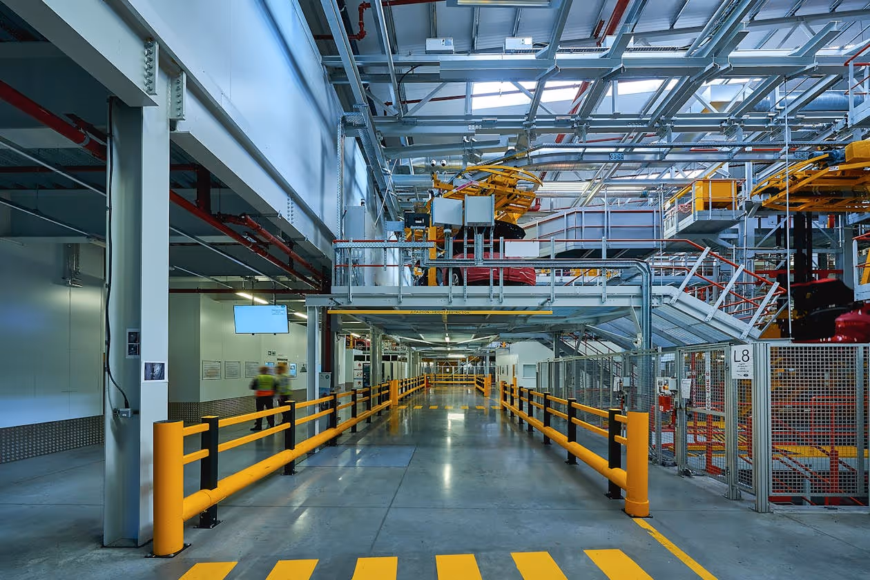 A long hallway with yellow railings and stairs.