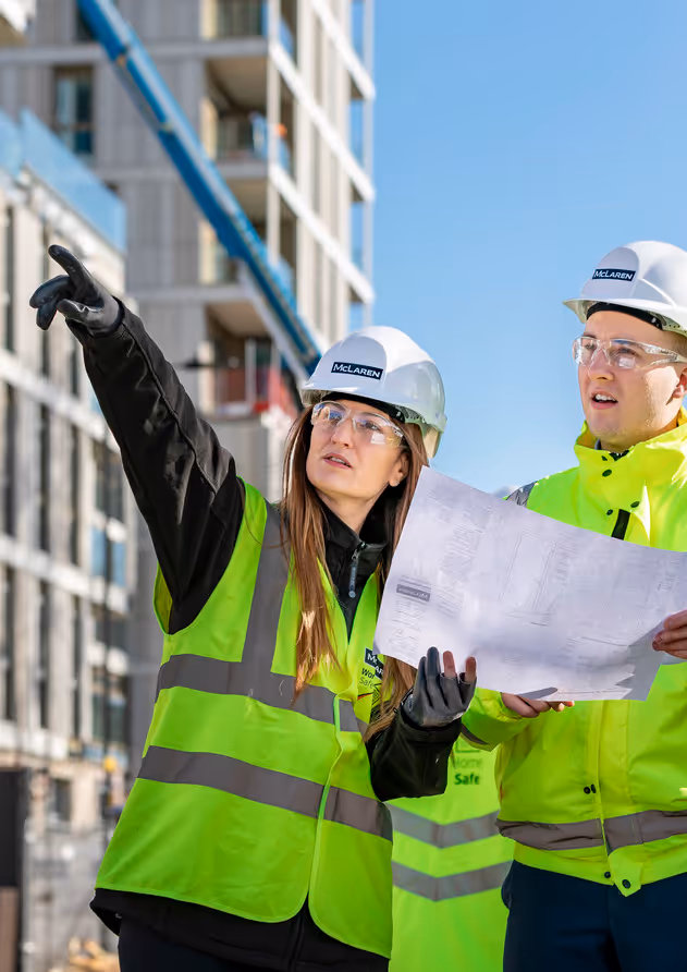 Two workers looking at a construction map