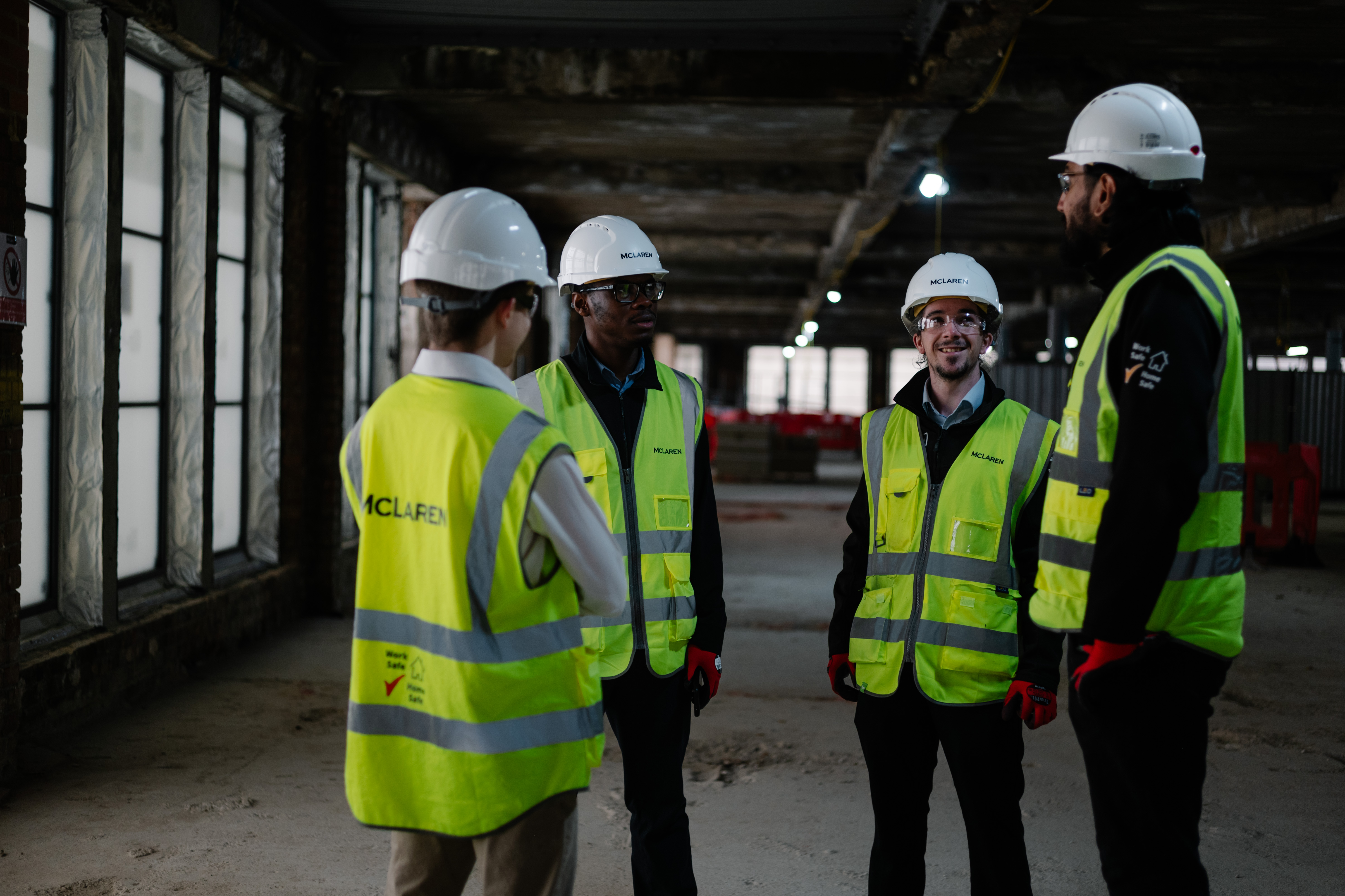 A group of men in safety vests talking to each other.