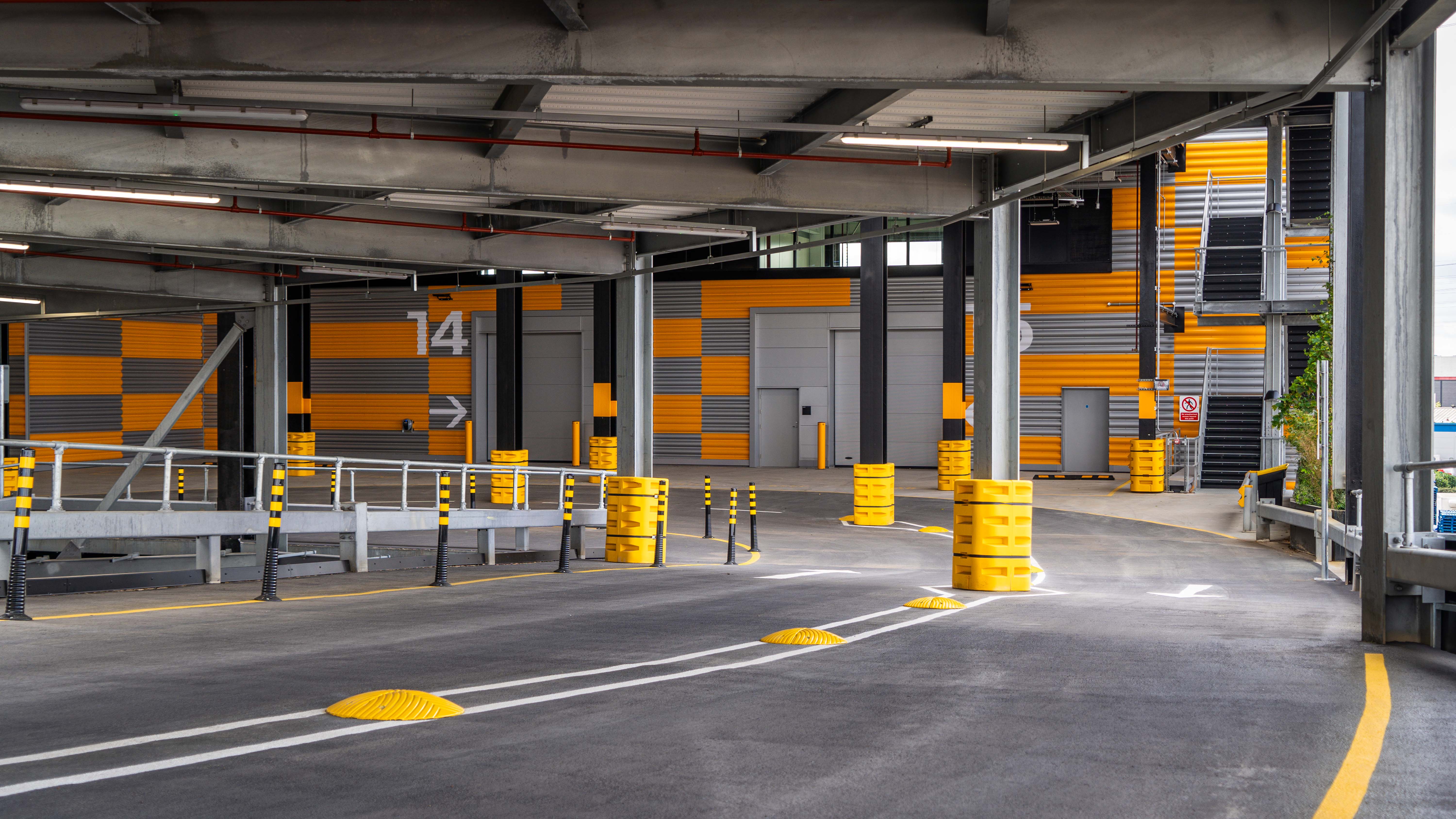 An empty parking garage with yellow barriers around it.