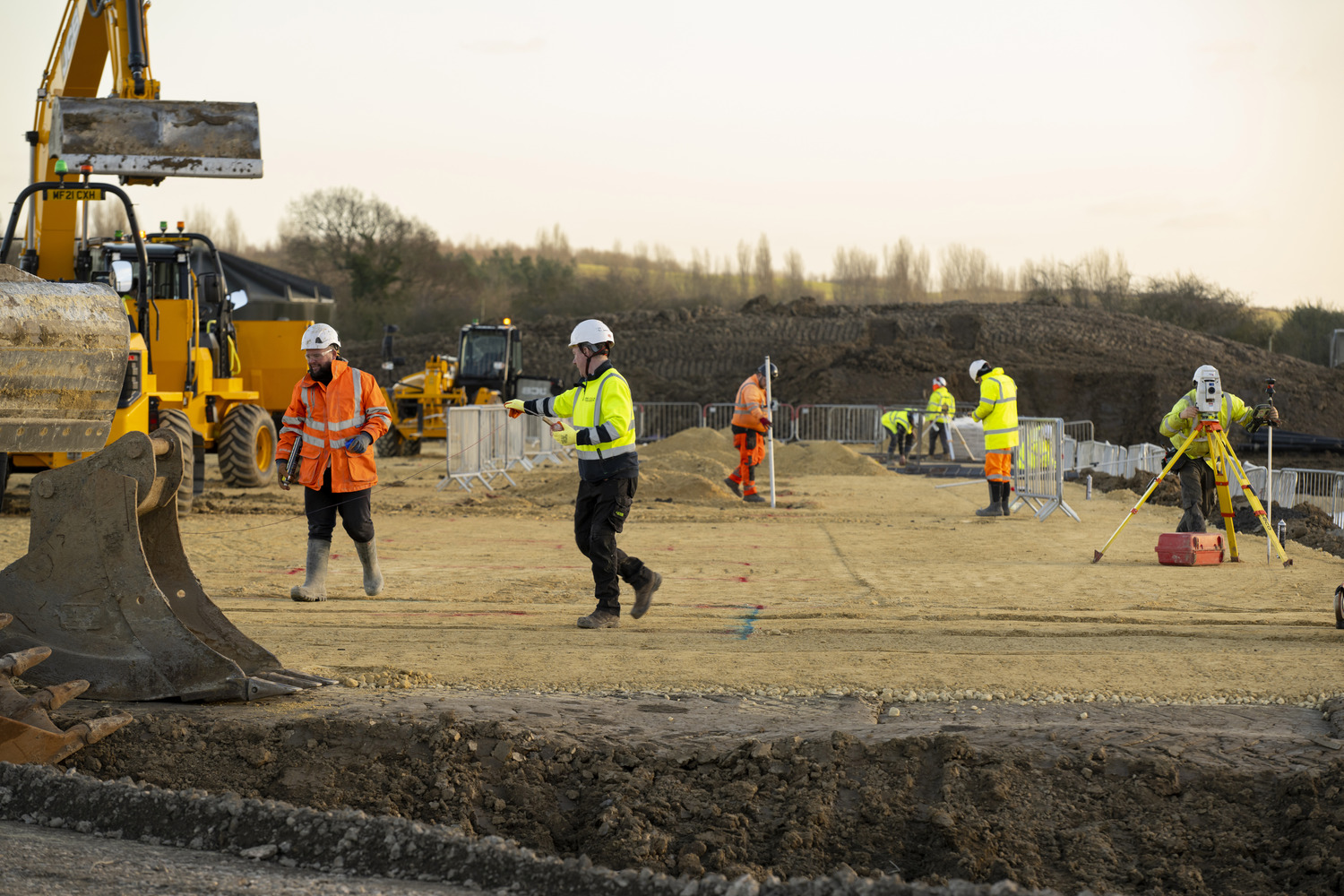 A group of construction workers standing around a construction site.