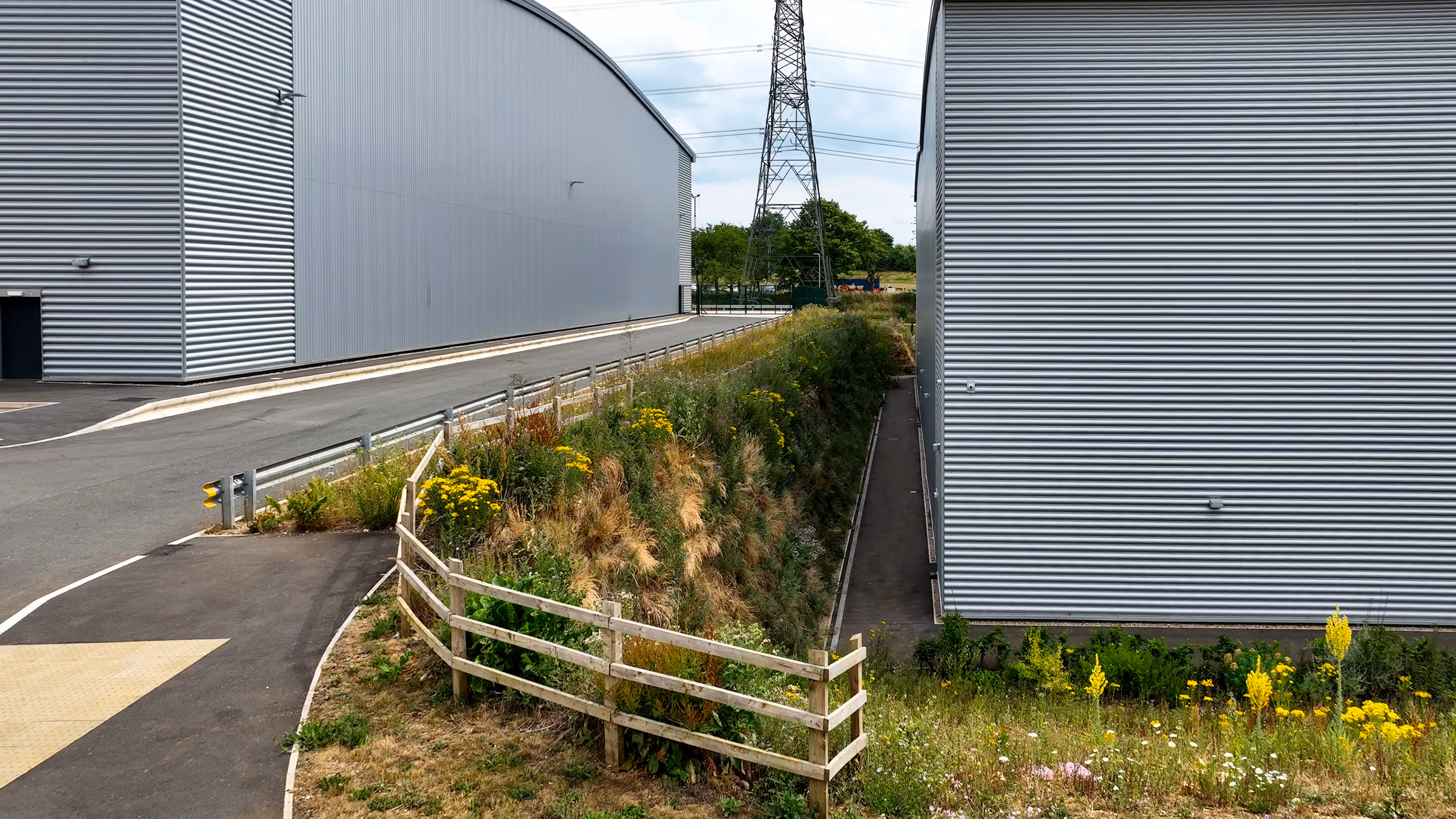 A building with a green roof next to a road.