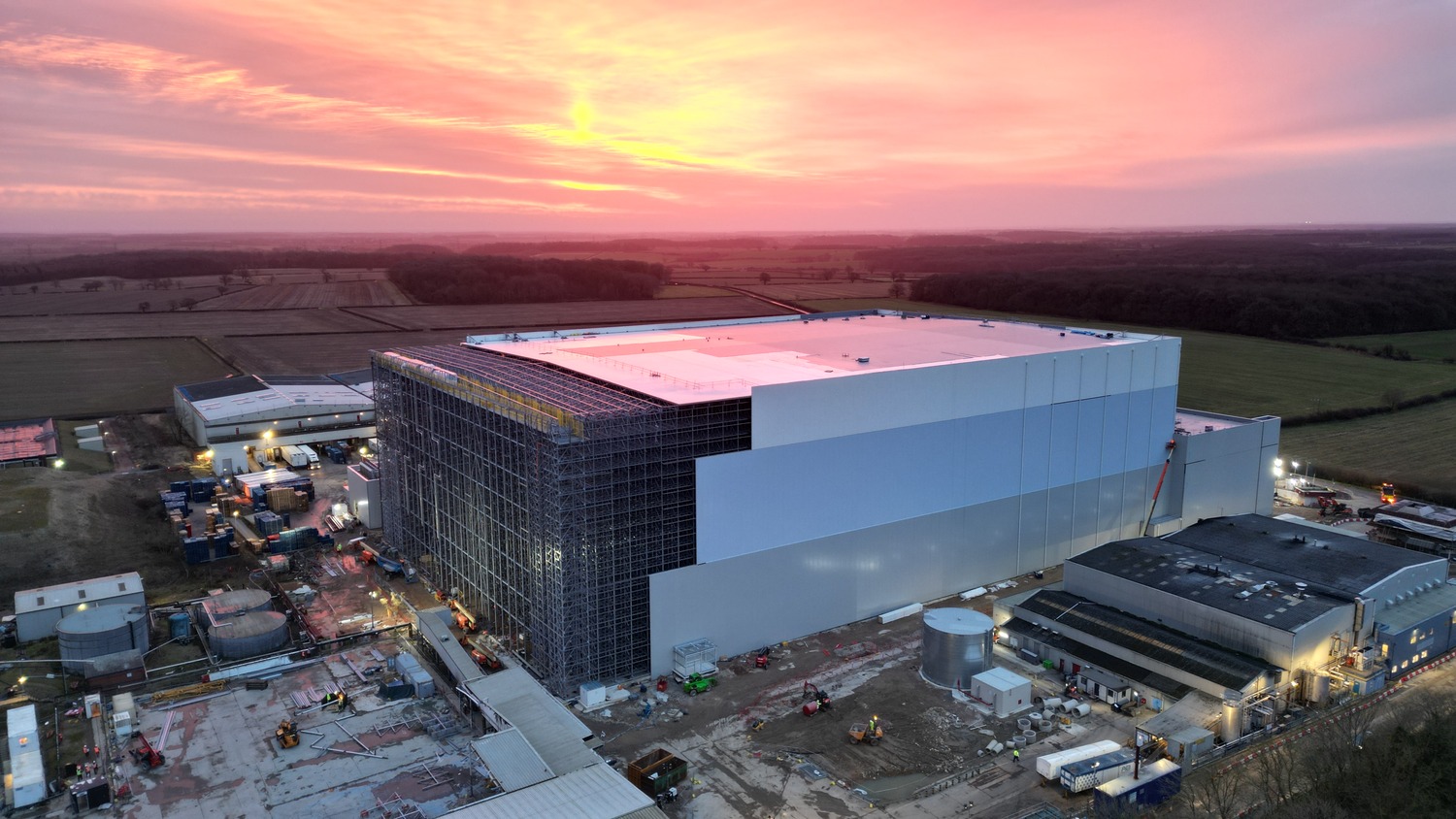 An aerial view of a large building with a sunset in the background.