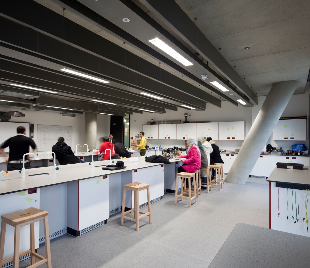 A group of people sitting at a table in a lab.