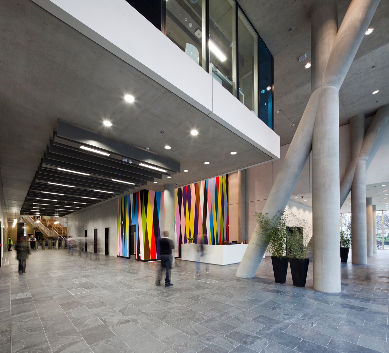 A large building with a bunch of people walking around it.
