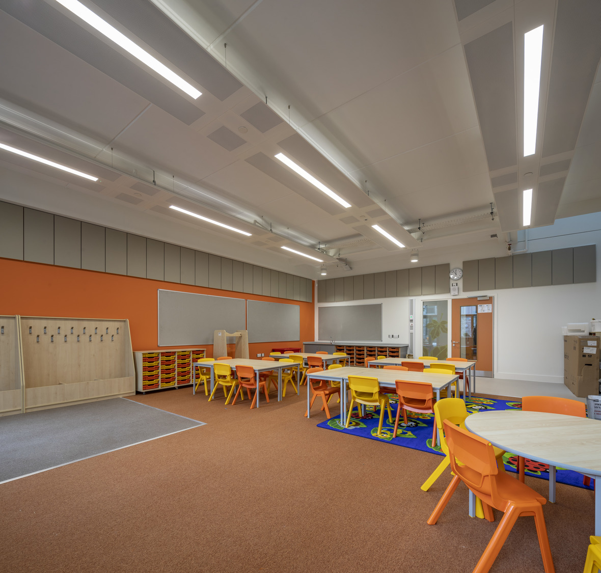 A classroom with tables, chairs, and a chalkboard.
