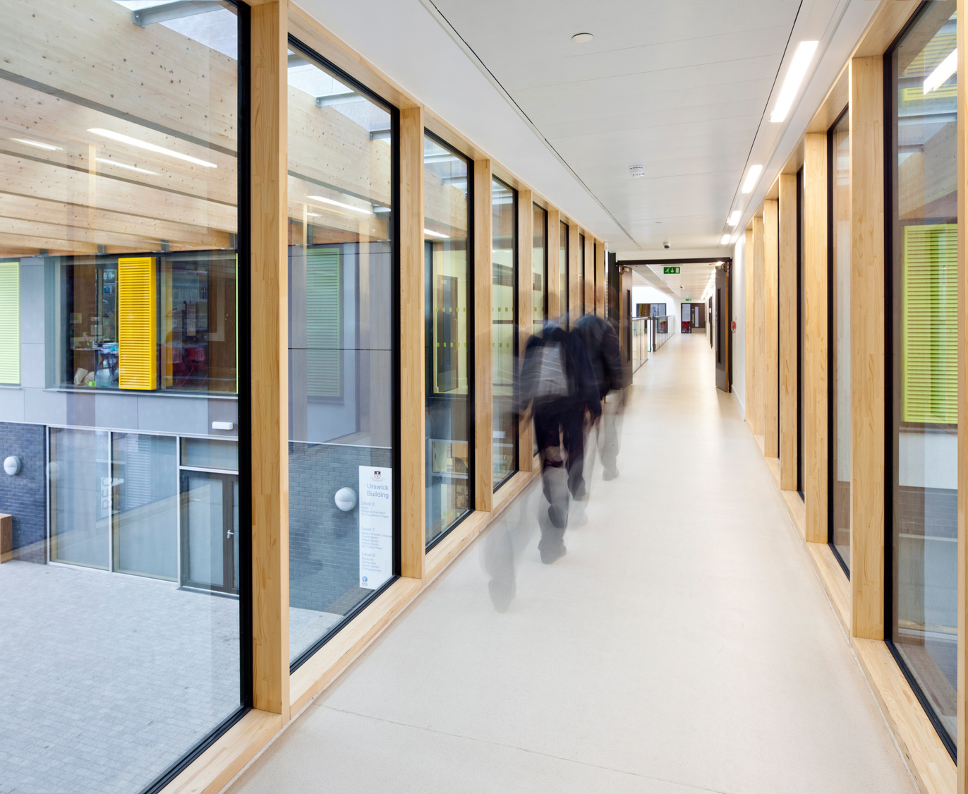A group of people walking down a long hallway.