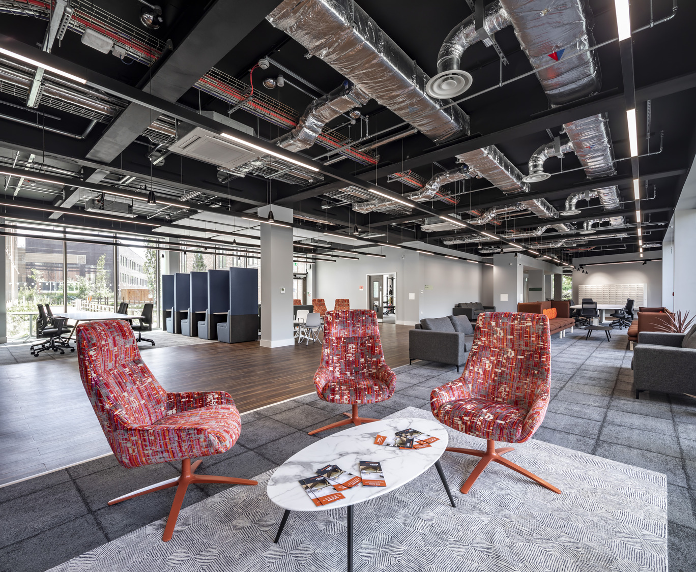 A room with chairs, tables, and a coffee table.
