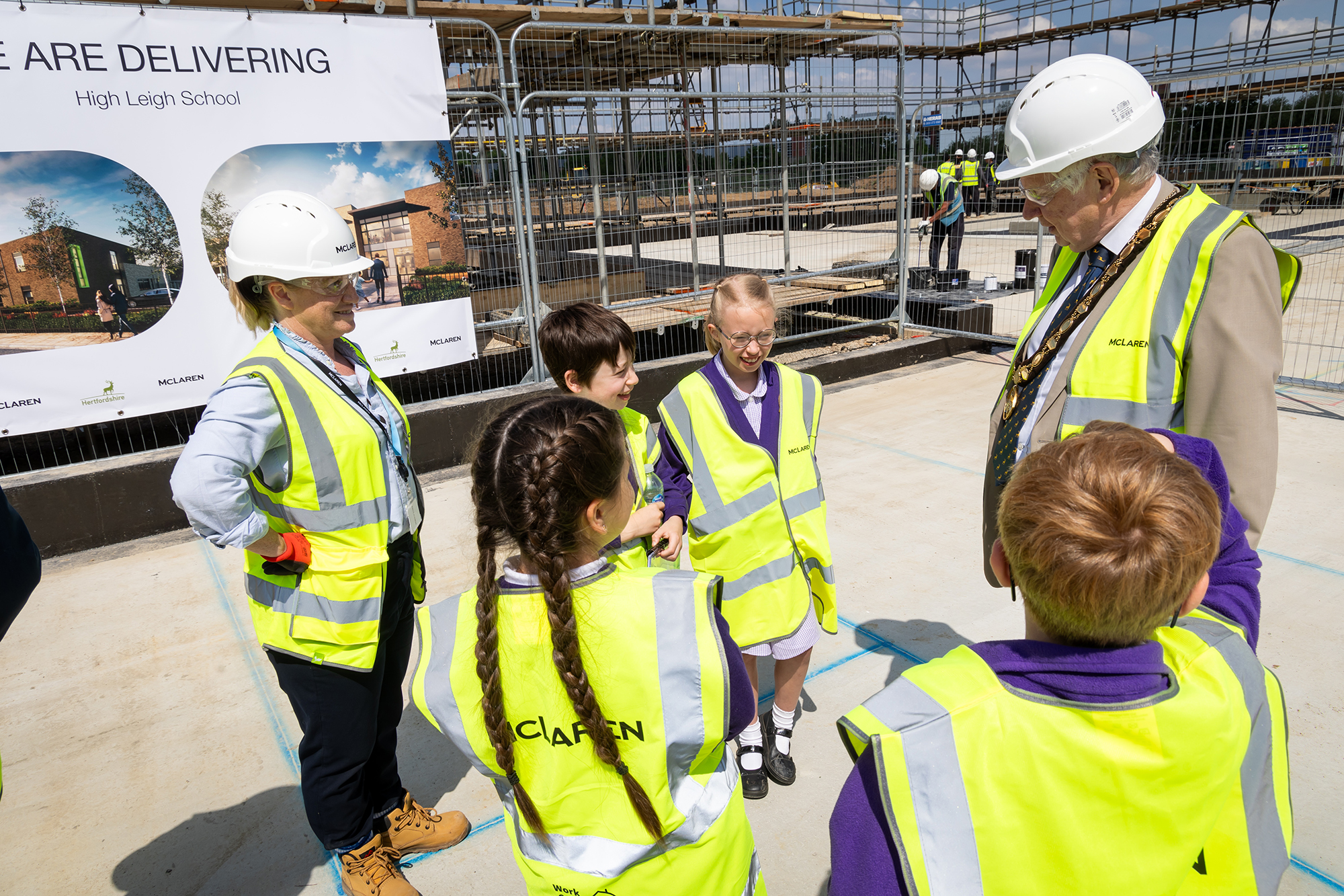 A group of people in safety vests talking to each other.