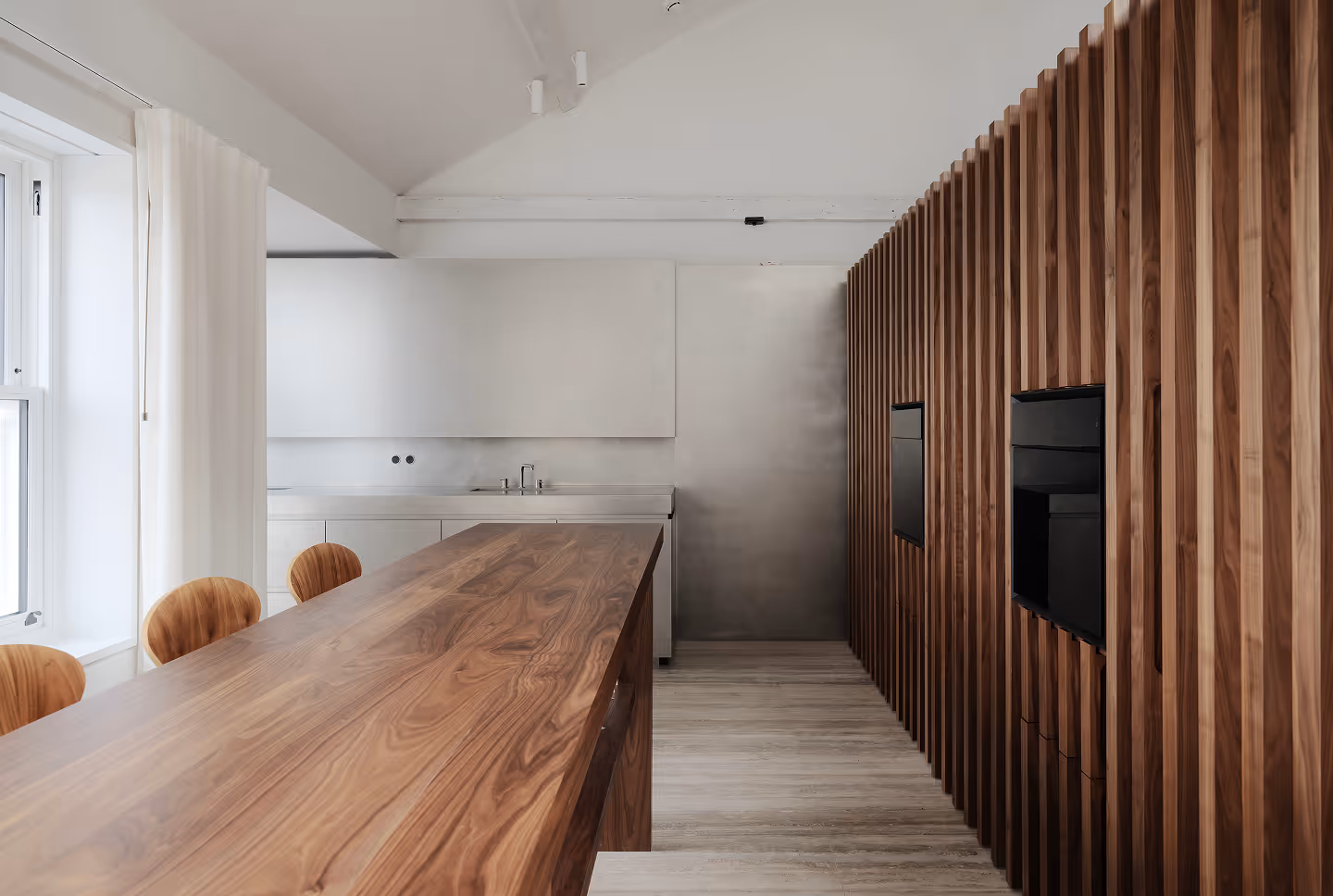 A room with a big wooden table and wooden wall fittings