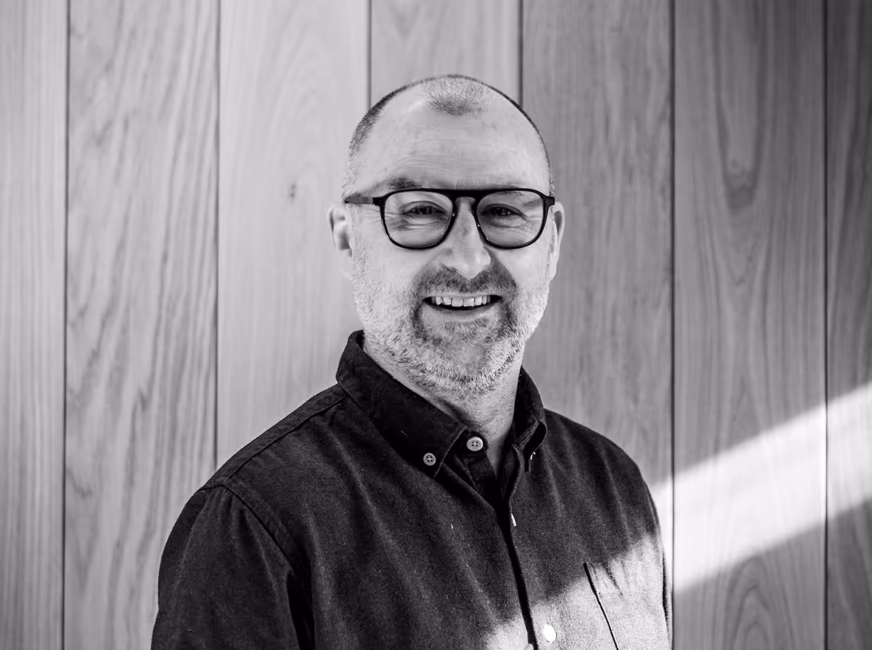 A black and white photo of a man smiling