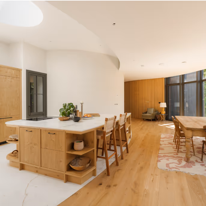 A living room with white walls and brown wood furnishings
