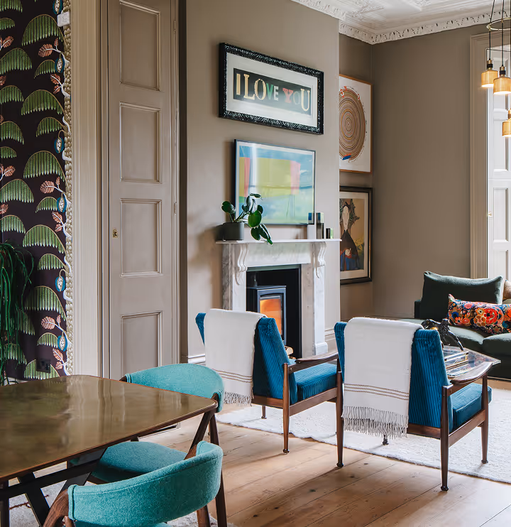 A room with blue chairs, tables, frames and carpets.