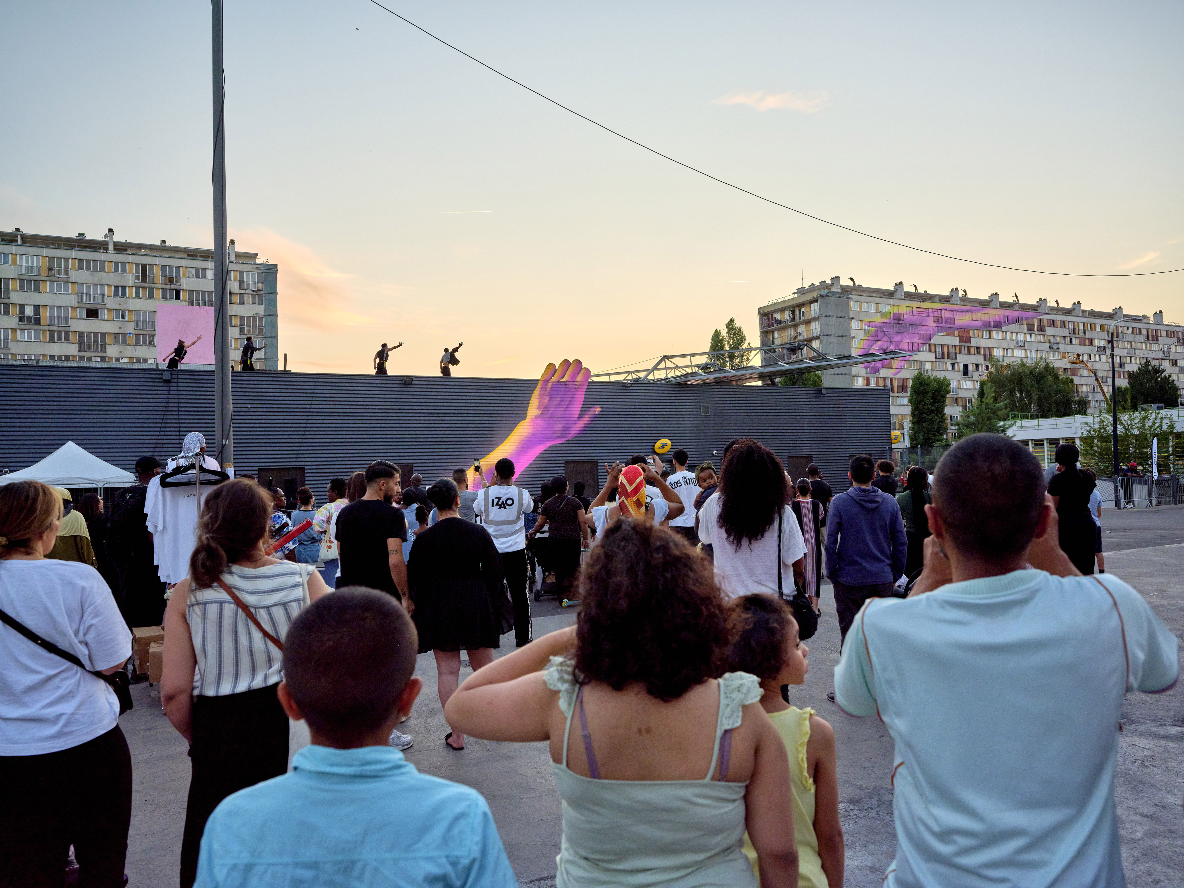 HU.MAINS : danseurs sur les toits et fresques de mains géantes devant le public, Clichy-sous-Bois