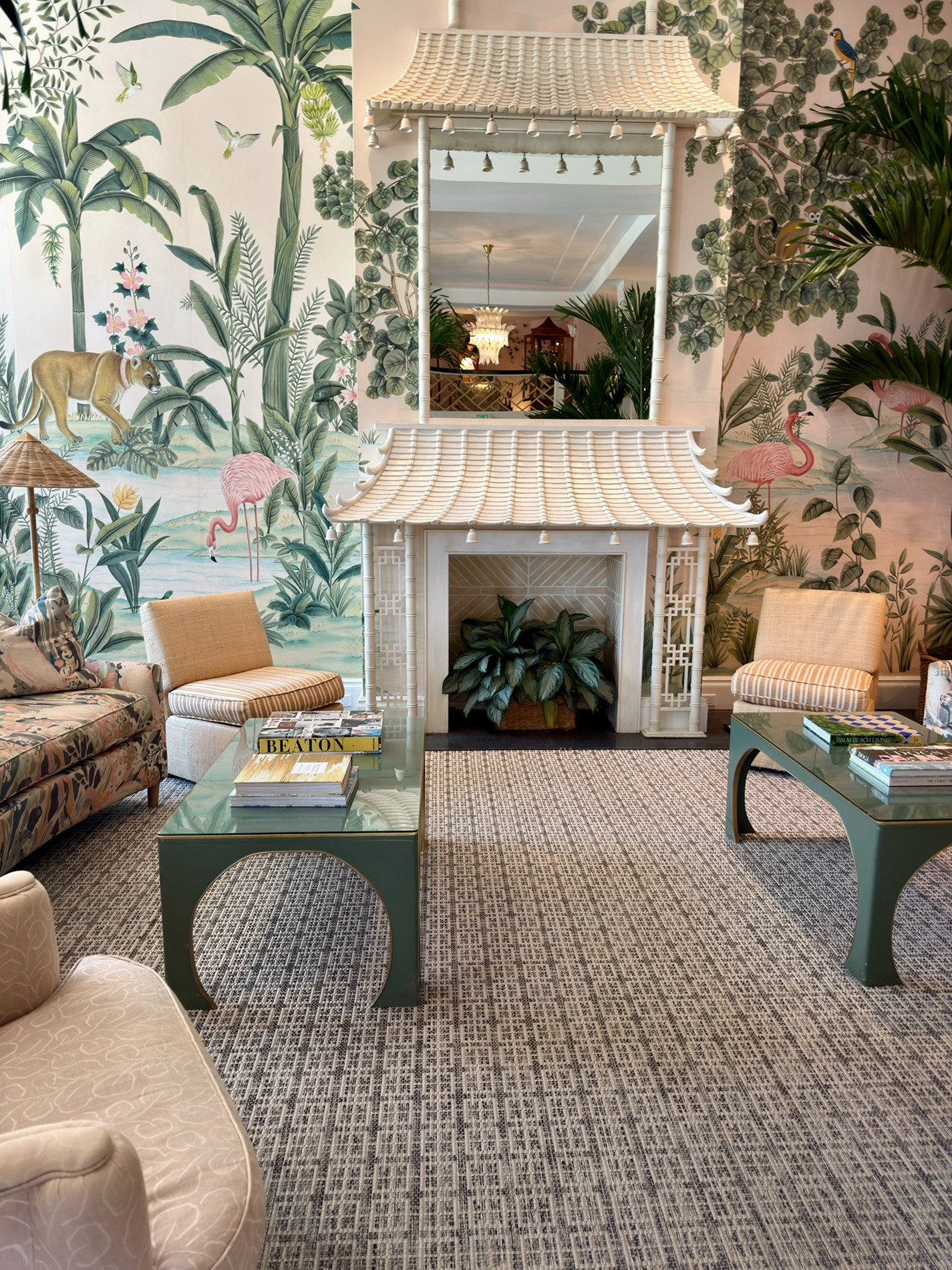 Tropical lobby at The Colony Hotel in Palm Beach featuring hand-painted murals and a decorative fireplace.