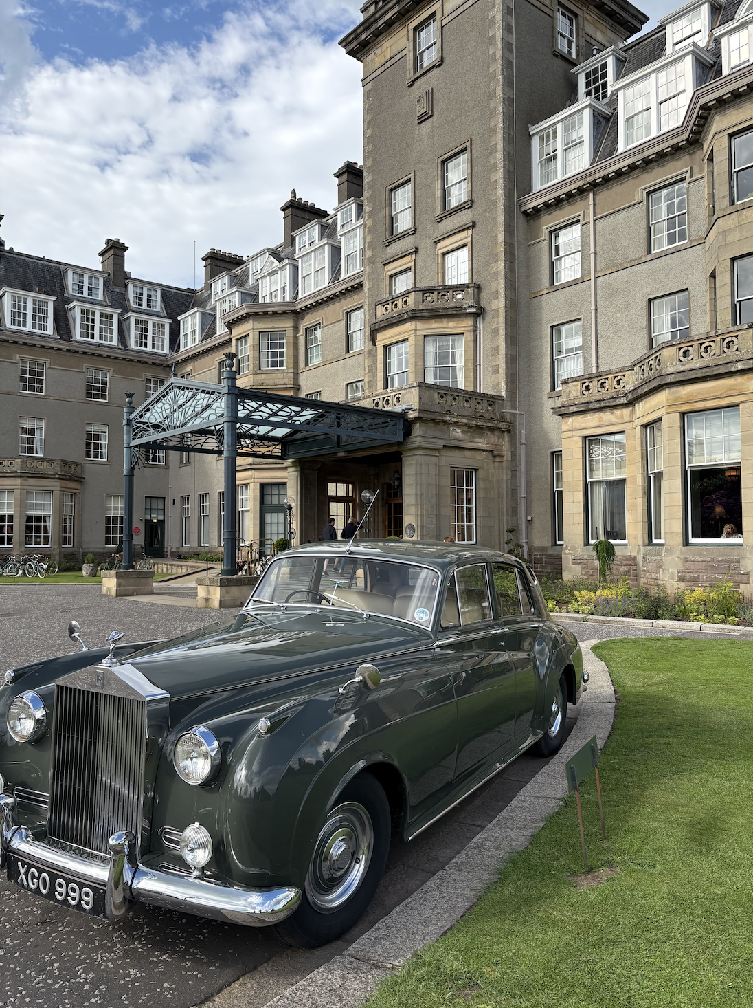 Historic exterior of Gleneagles Hotel in Perthshire, Scotland with a vintage Rolls-Royce parked at the entrance